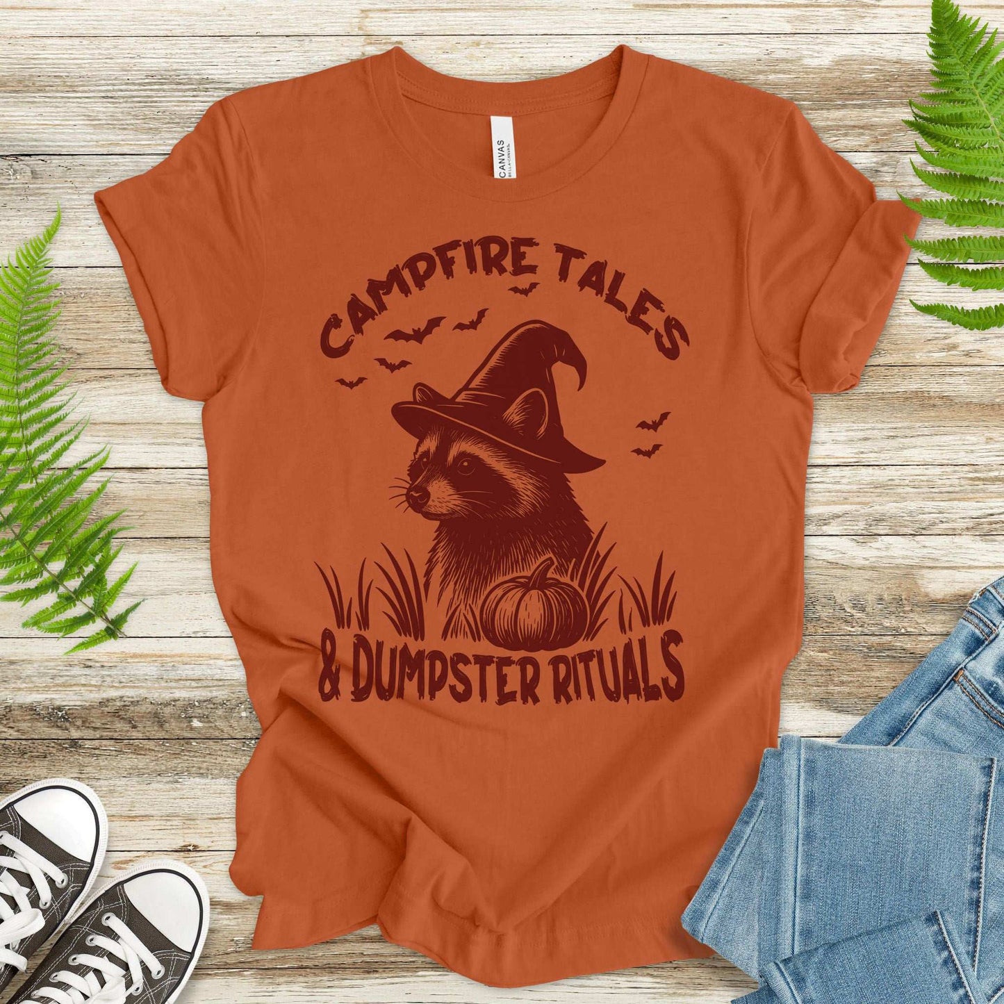 Campfire Tales raccoon Halloween T-shirt featuring a witch raccoon with pumpkin design in retro style.