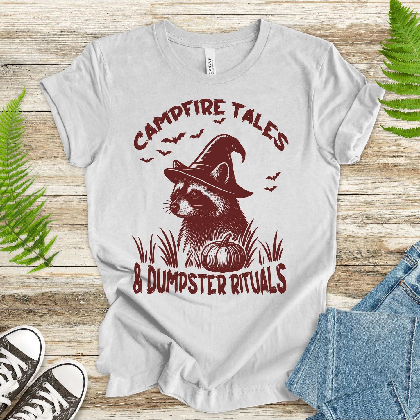 Campfire Tales Raccoon Halloween T-shirt with witch hat and pumpkin design for spooky vibes.