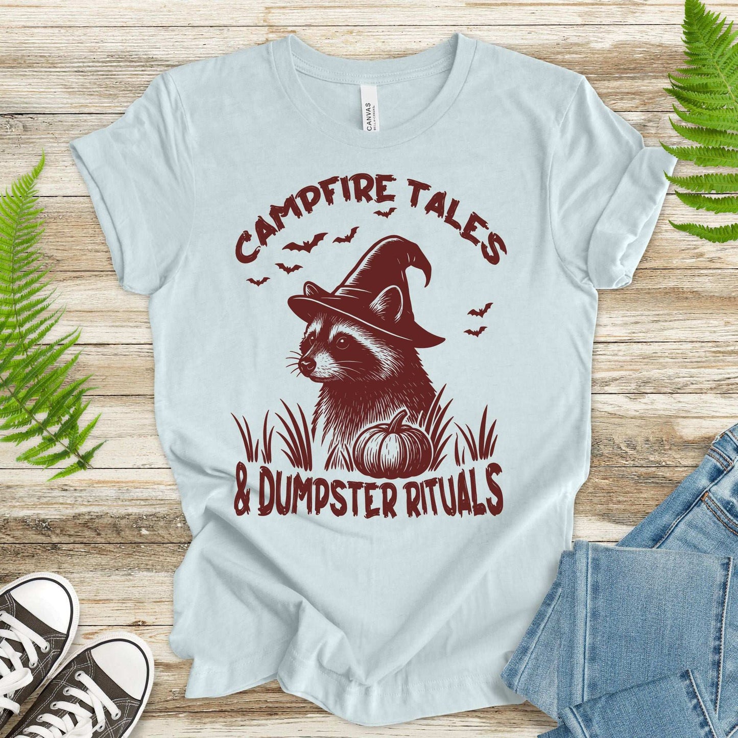 Campfire Tales Raccoon T-shirt featuring a spell-casting raccoon in a witch hat with a pumpkin, perfect for Halloween.