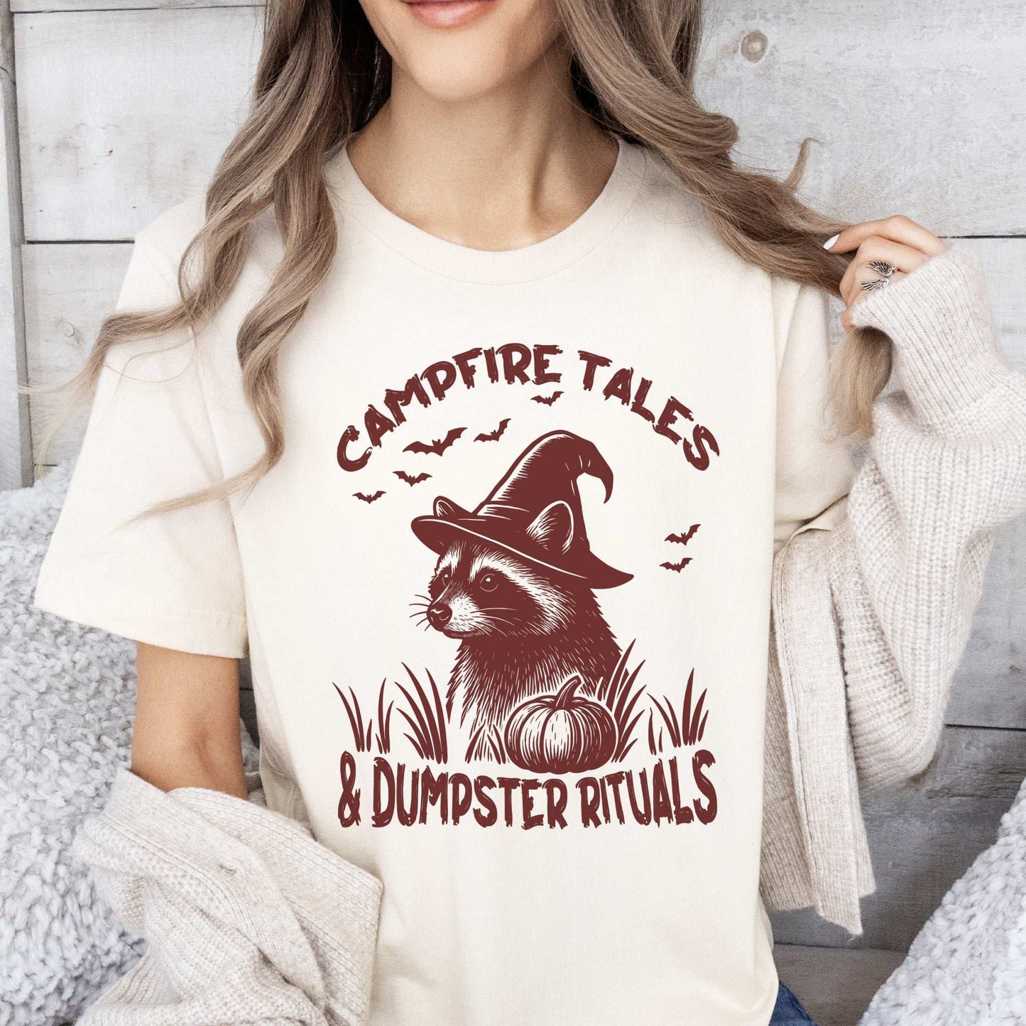 Campfire Tales Raccoon Halloween T-shirt featuring a witchy raccoon and pumpkin design.