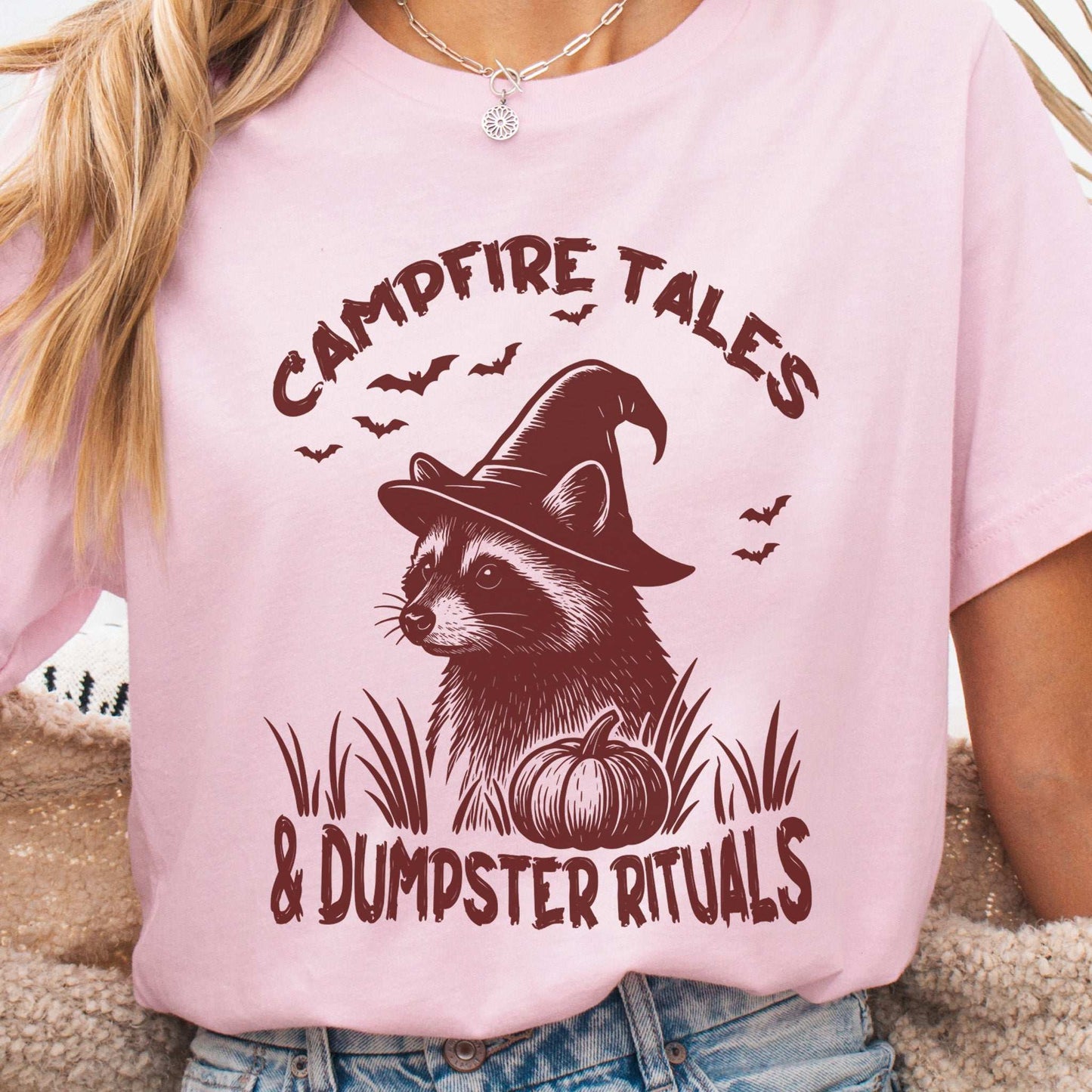 Campfire Tales Raccoon Halloween T-shirt featuring a raccoon in a witch hat with spooky pumpkin design.