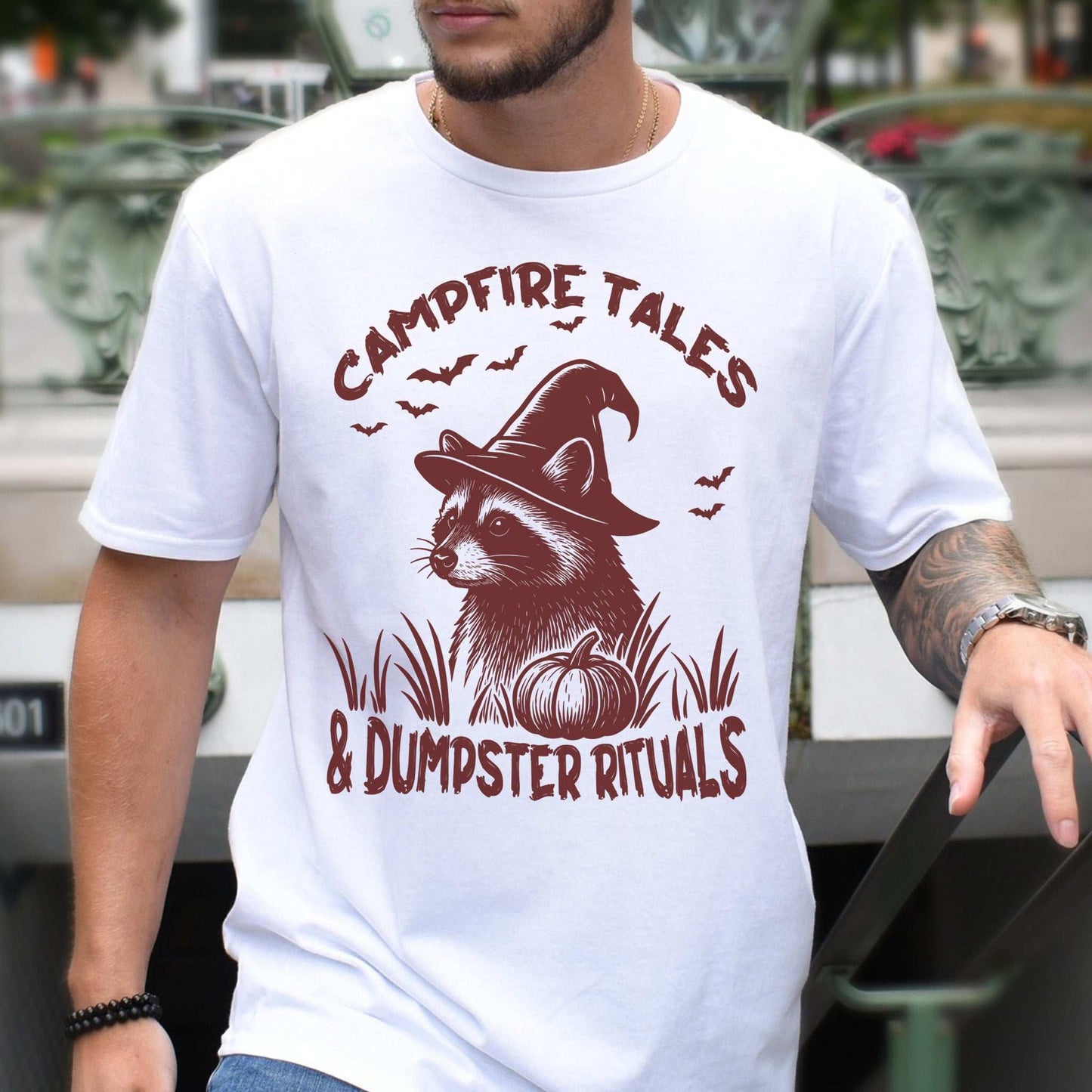 Campfire Tales Raccoon Halloween T-Shirt featuring a raccoon in a witch hat with spooky graphic design.