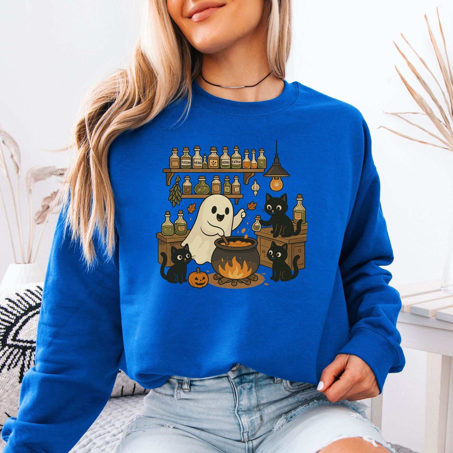Ghost & Black Cats Halloween Sweatshirt featuring a ghost chef with black cats and potion bottles, perfect for Halloween.