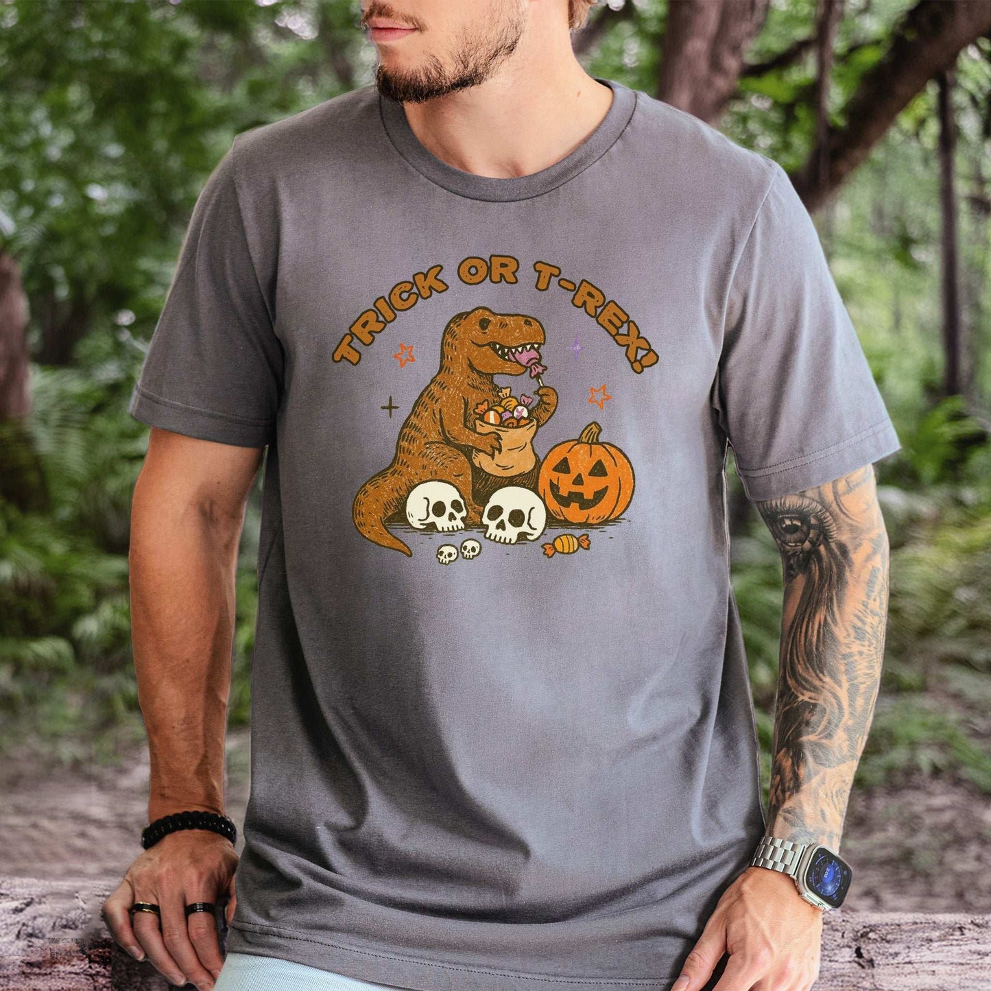 T-Rex Halloween T-Shirt featuring a dino with candy, pumpkins, and skeletons for a fun Trick or Treat vibe.