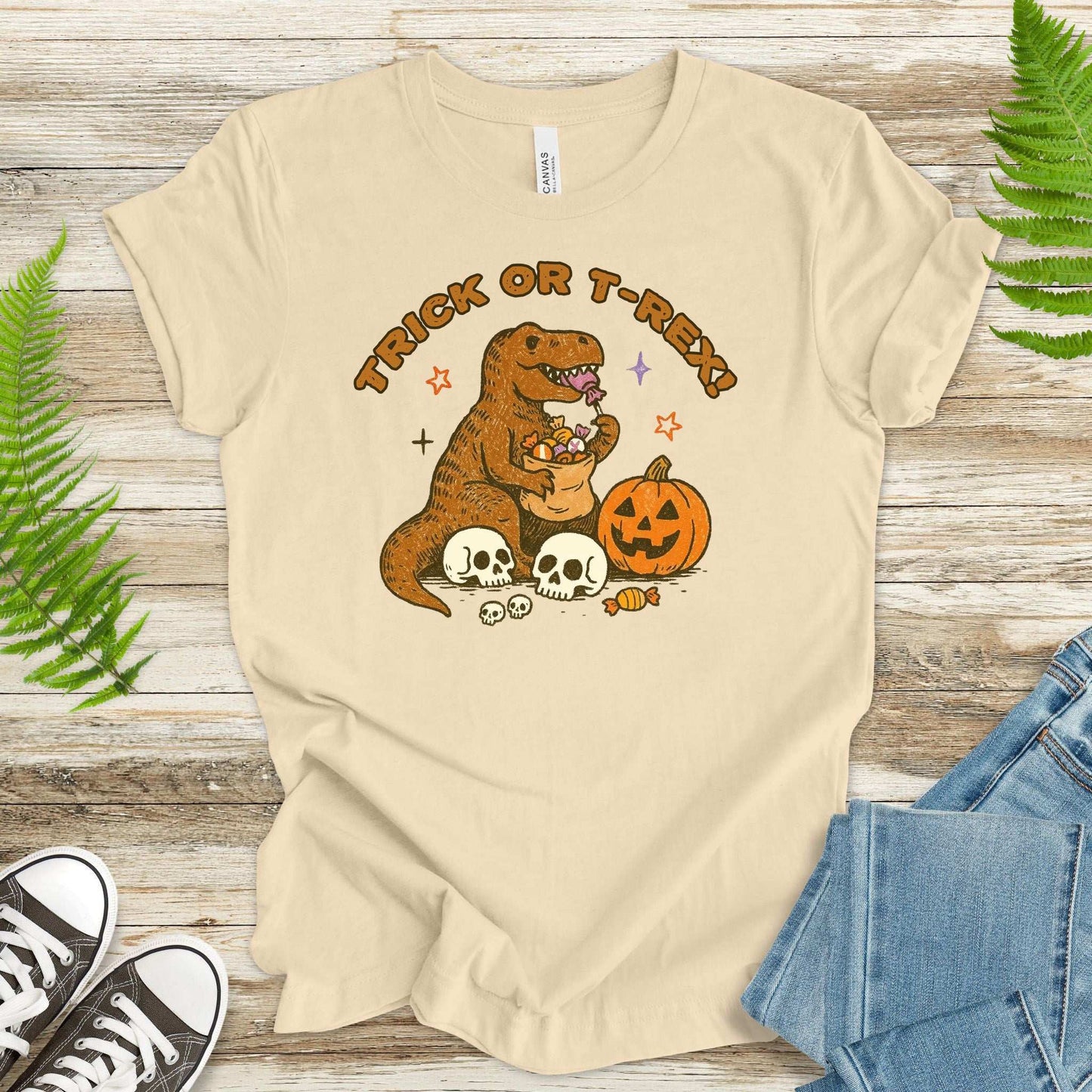 T-Rex Halloween T-Shirt featuring dino with candy and pumpkin in a fun vintage style for Halloween 2025.