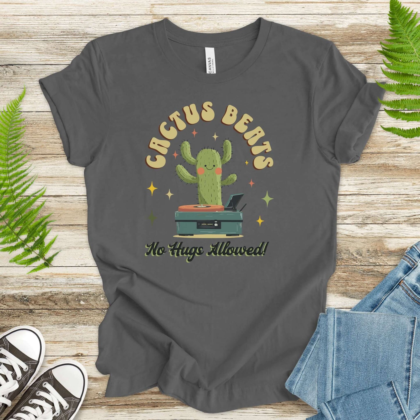 Funny retro cactus DJ T-shirt in soft cotton, featuring the phrase 'Cactus Beats - No Hugs Allowed!' on a playful gray background.
