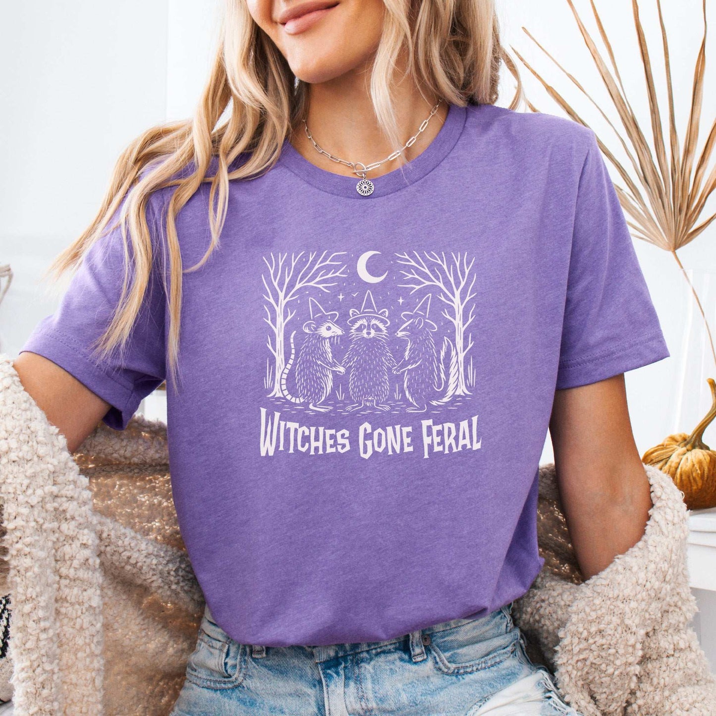 Witches Gone Feral Halloween T-shirt featuring raccoon, opossum, and skunk under crescent moon, perfect for feral witches.