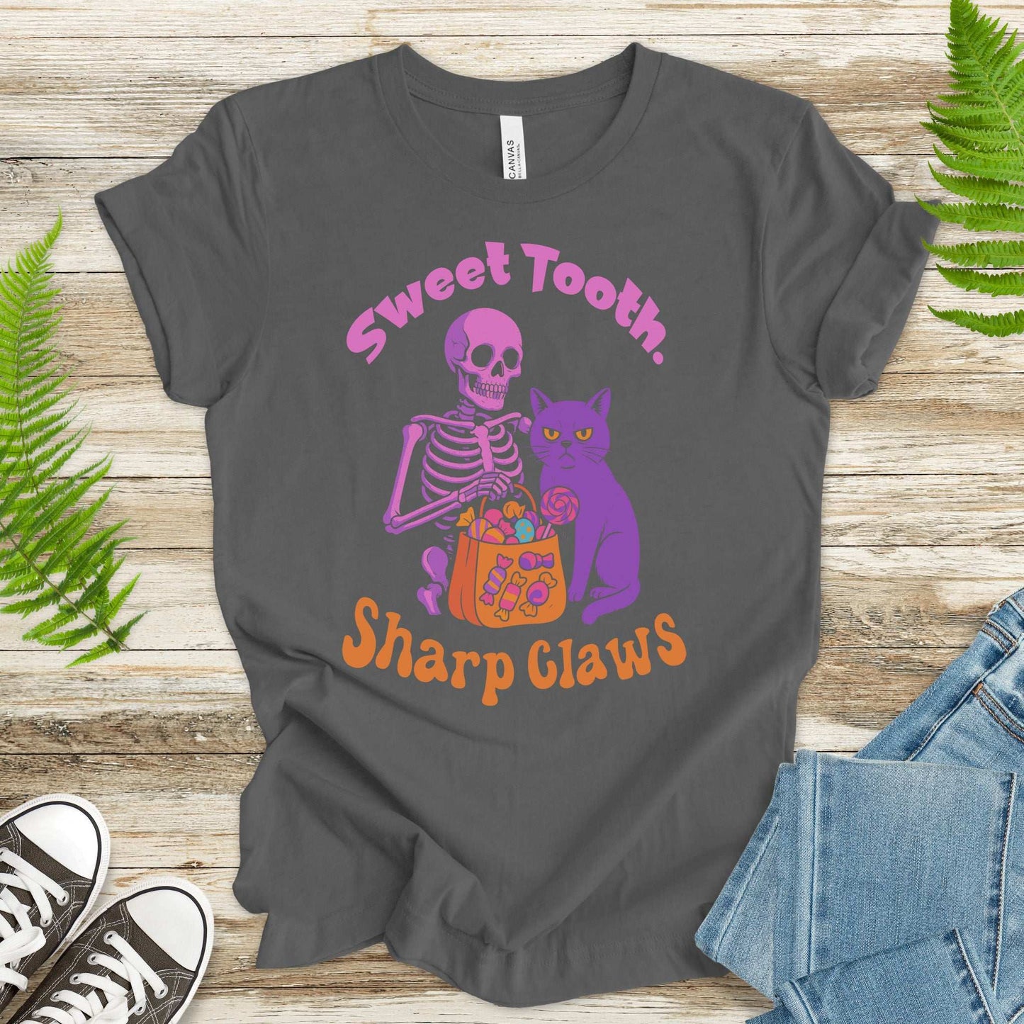 Skeleton and grumpy cat Halloween T-shirt featuring sweet tooth and sharp claws design, perfect for spooky candy lovers.