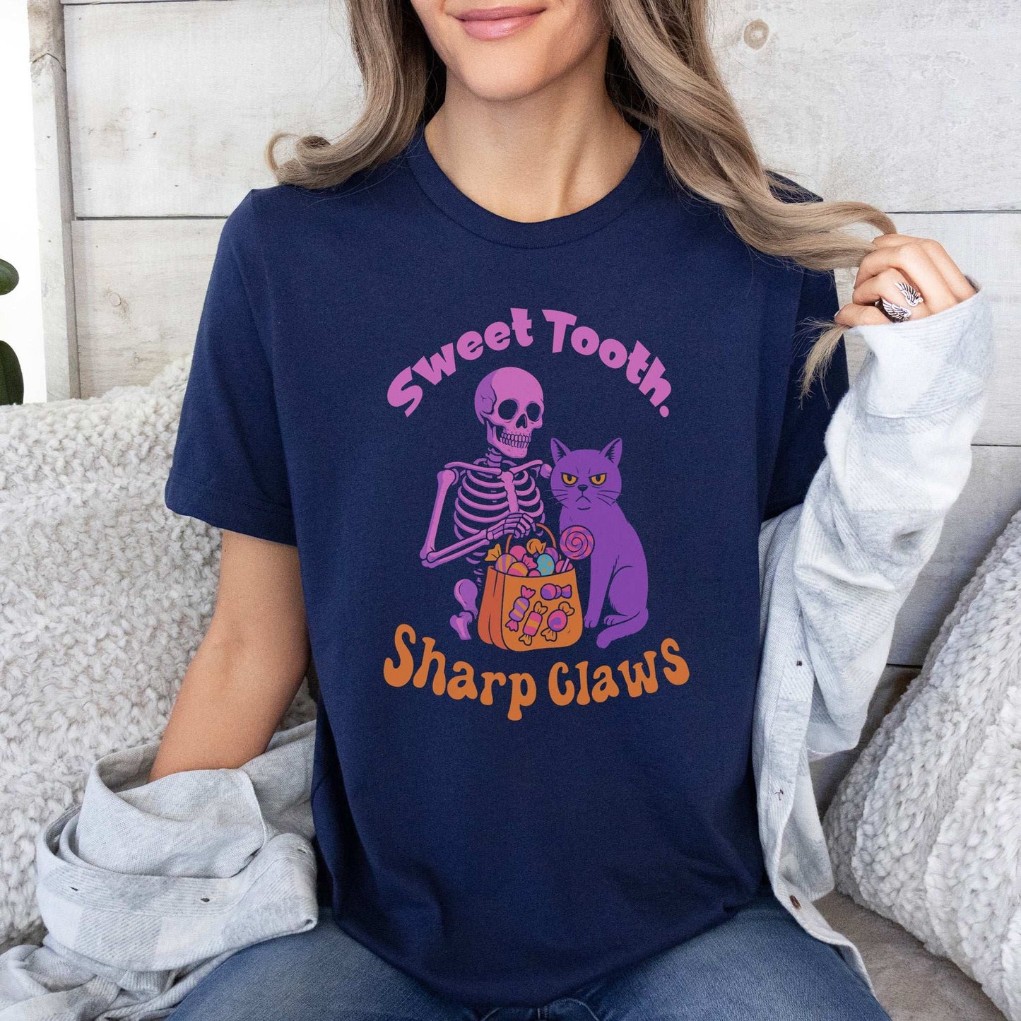 Skeleton and Grumpy Cat Halloween T-shirt with text 'Sweet Tooth, Sharp Claws' on a navy background.