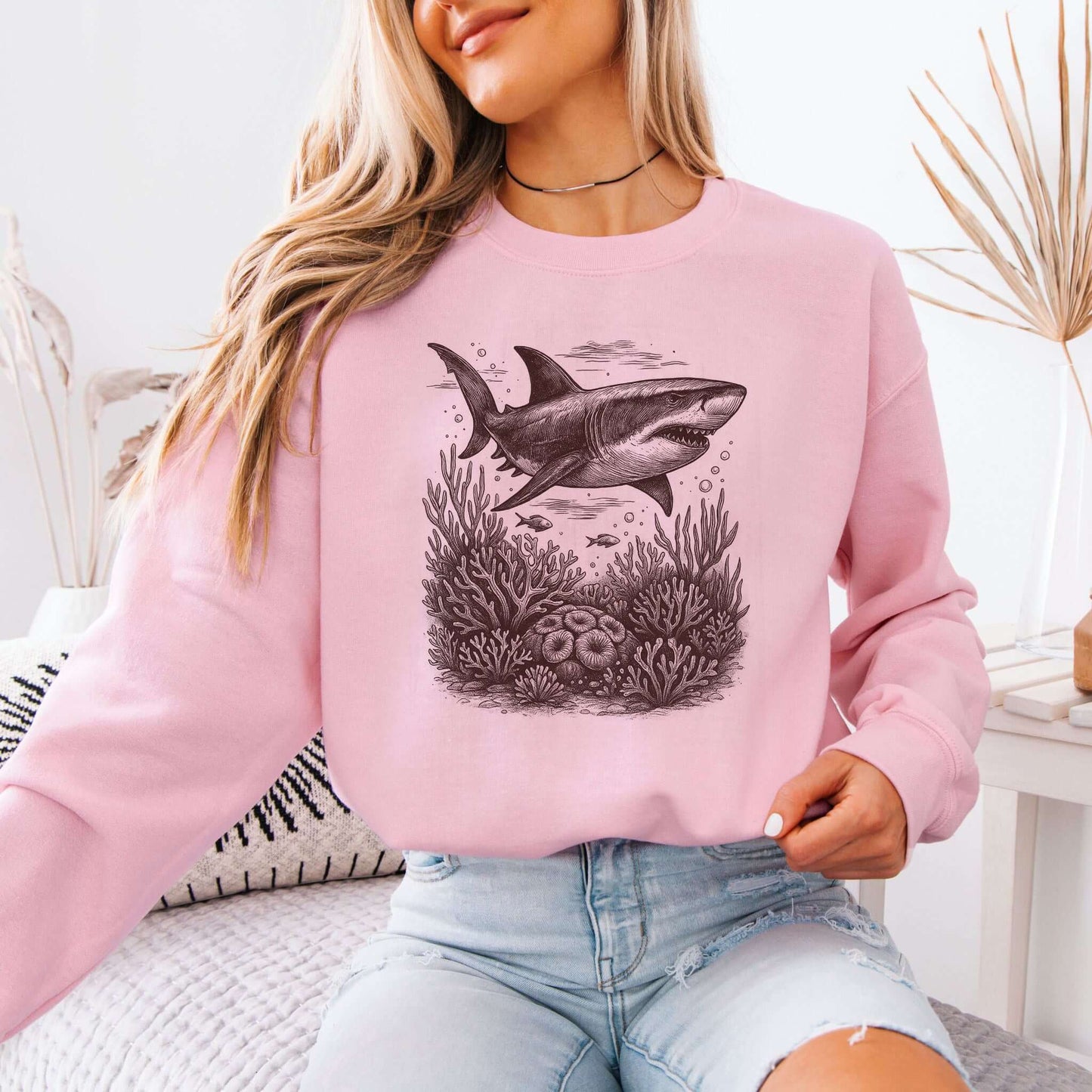 Model wearing a pink Shark and Coral Reef Sweatshirt with vintage shark graphic and coral reef design.