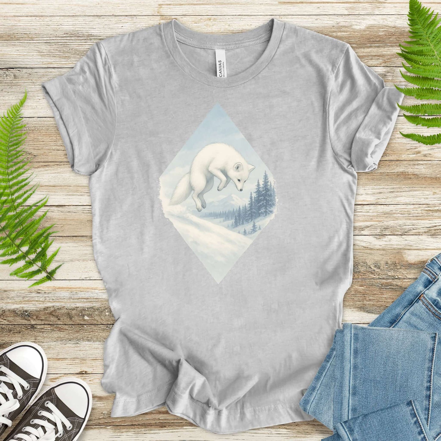 Jumping white fox in snow graphic on a grey shirt, perfect for fantasy lovers and animal enthusiasts.