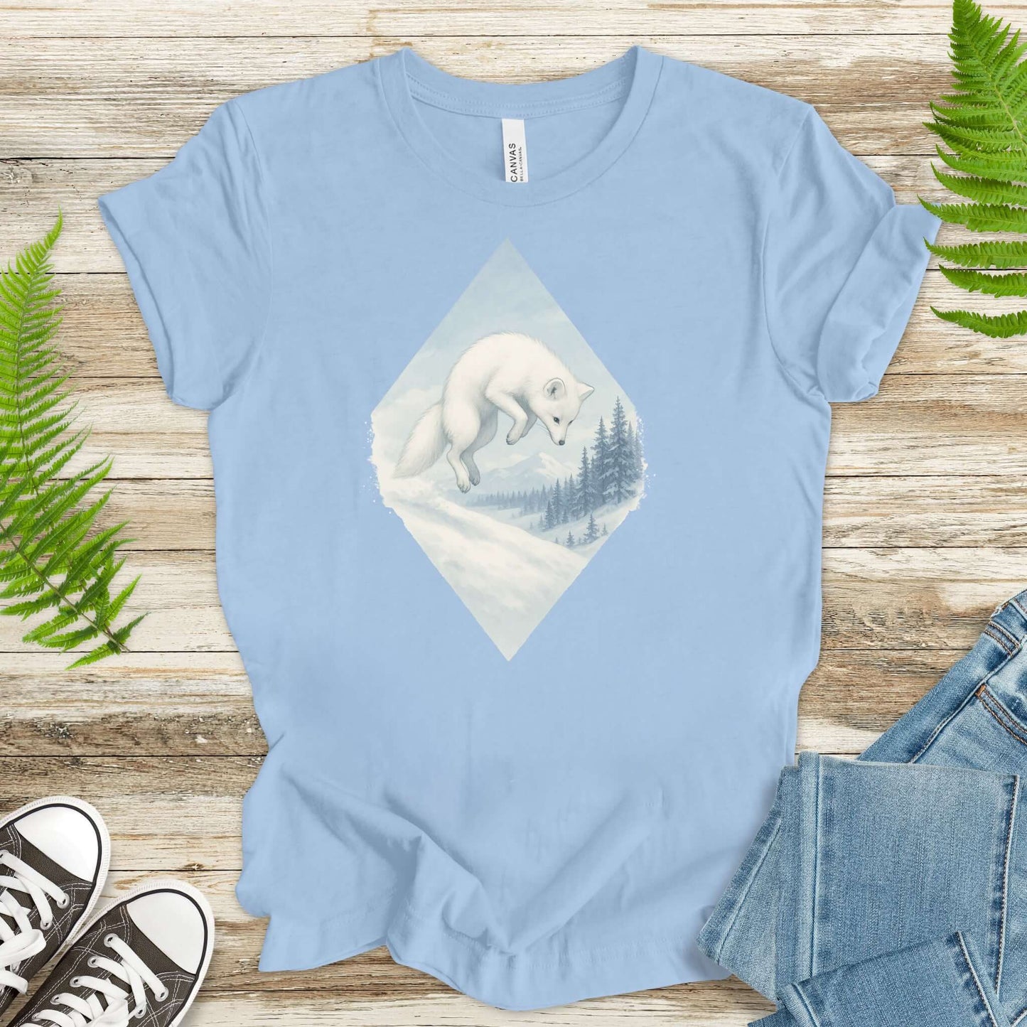 Jumping white fox in snow design on light blue shirt, perfect for fantasy lovers and animal enthusiasts.