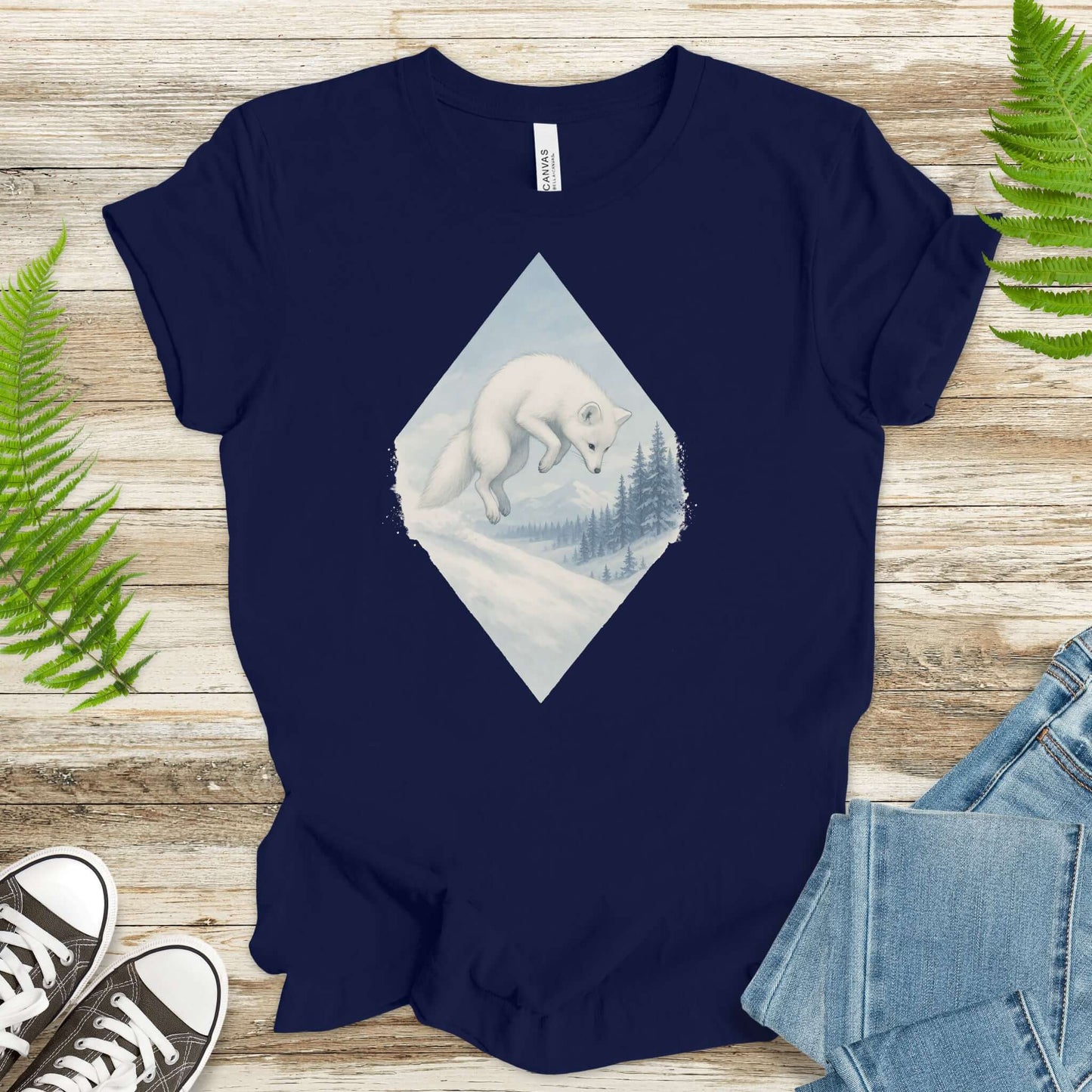 White fox leaping in snow on navy t-shirt; perfect for fantasy lovers and animal enthusiasts.