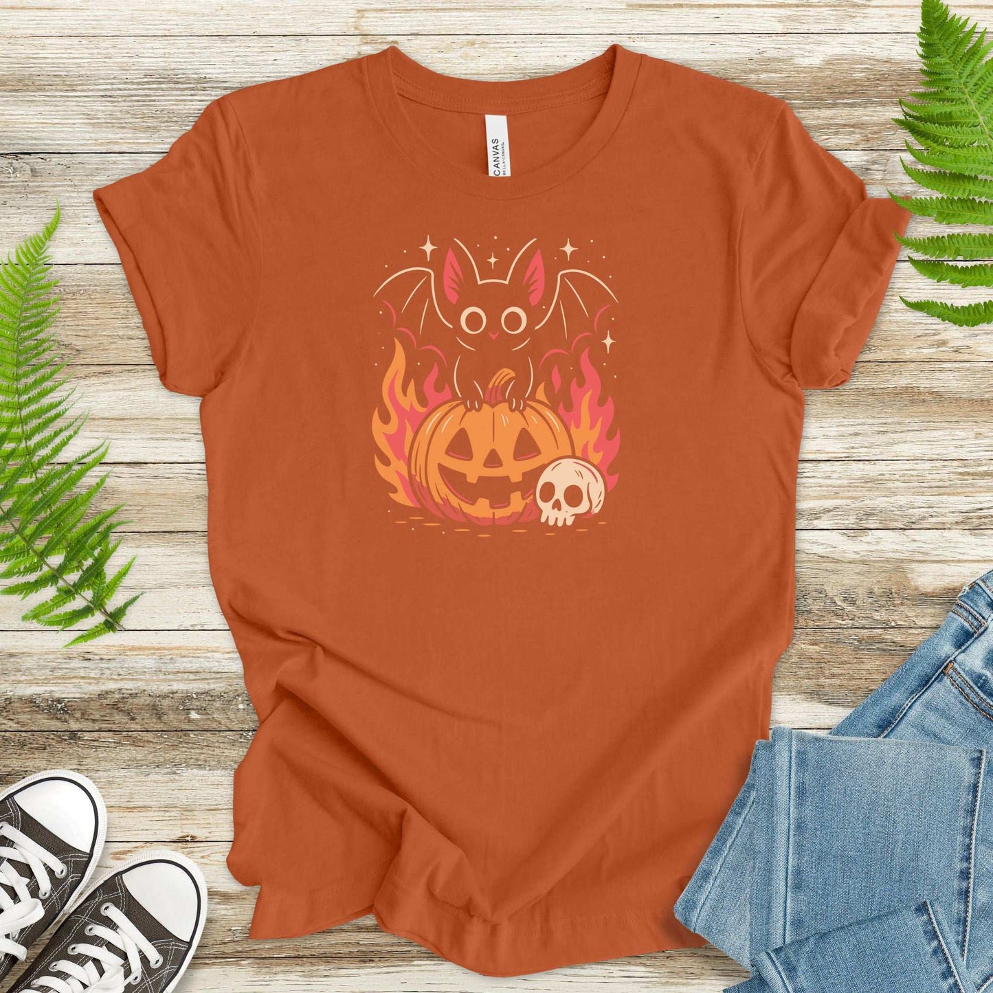 Spooky Bat Halloween T-Shirt featuring a cute bat on a pumpkin with flames, perfect for gothic autumn vibes.