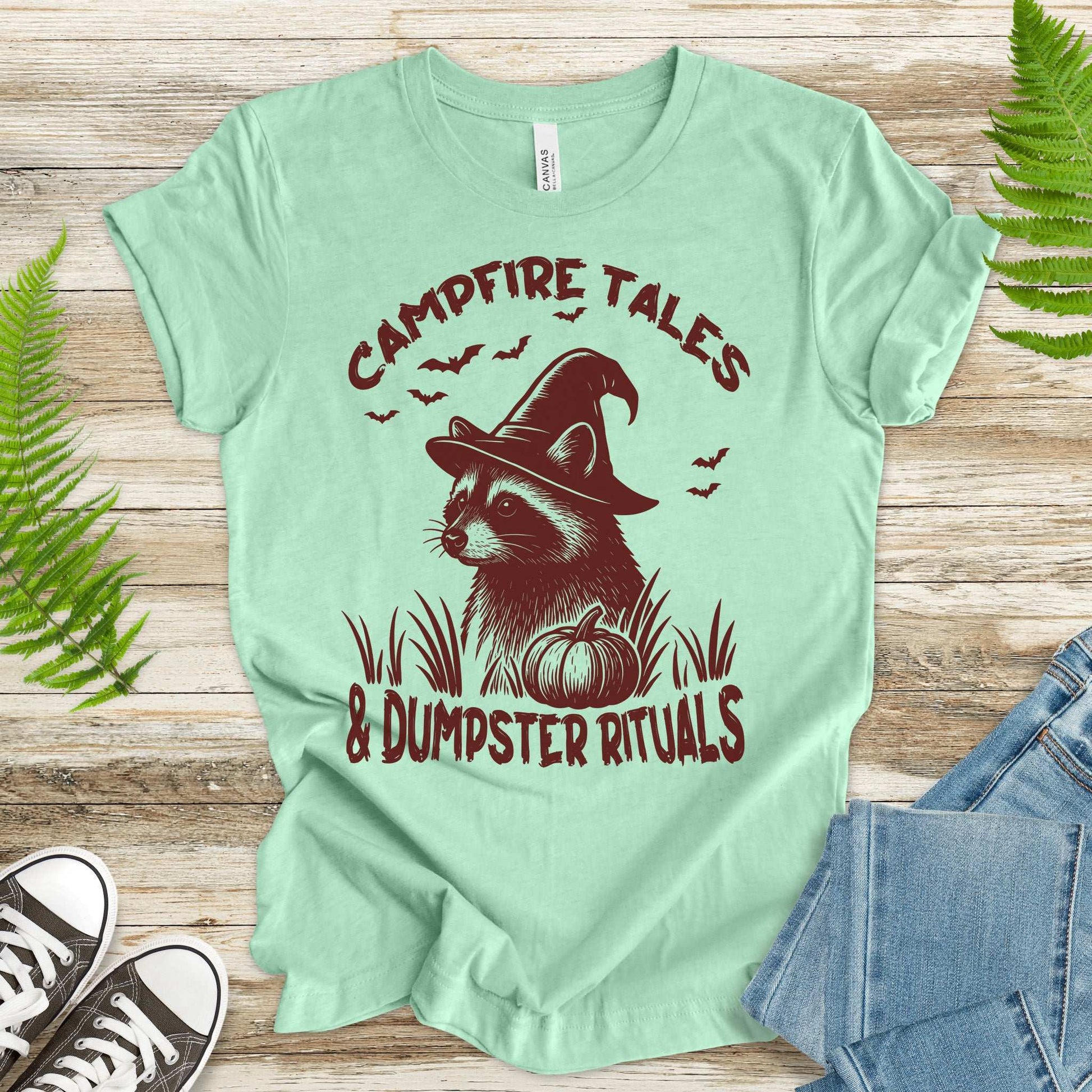 Campfire Tales Raccoon Halloween T-shirt featuring a witchy raccoon and pumpkin, perfect for spooky vibes.