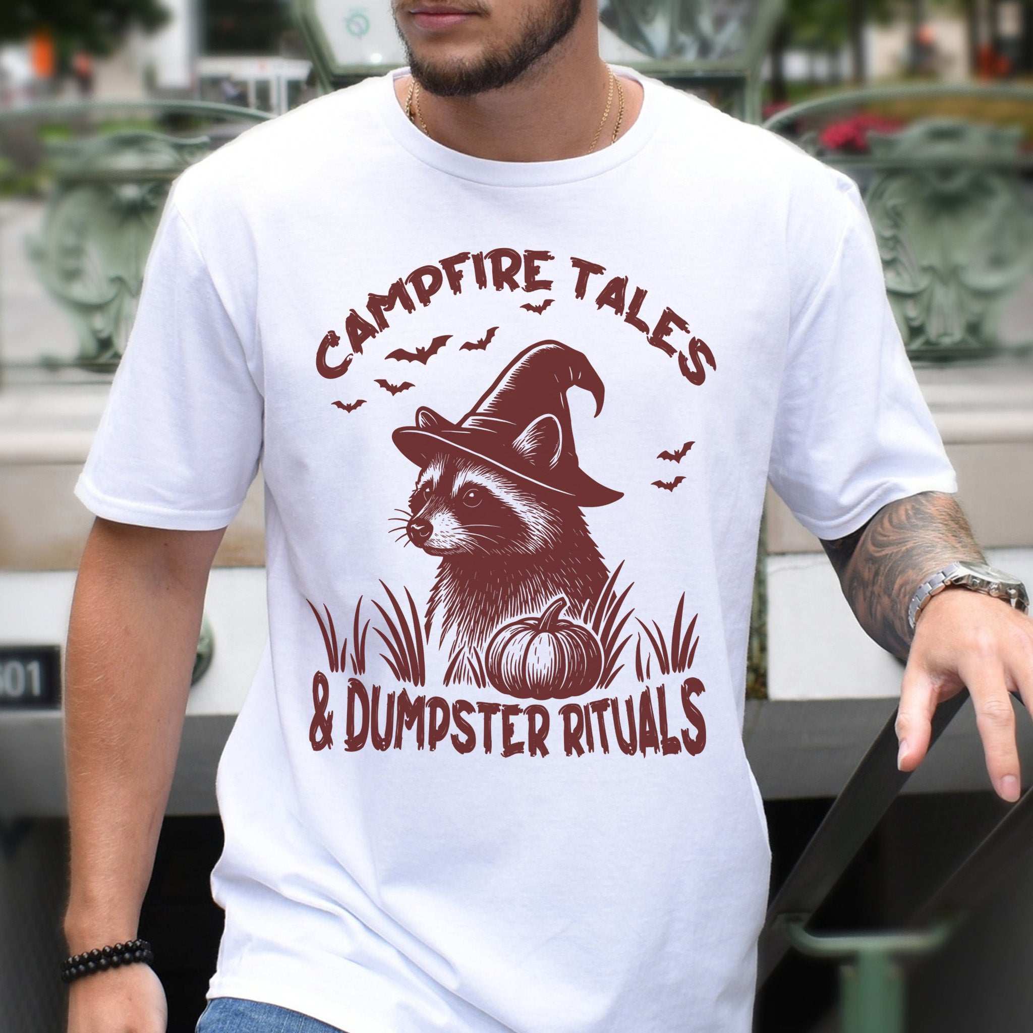 Campfire Tales Raccoon Halloween T-Shirt featuring a raccoon in a witch hat with spooky graphic design.