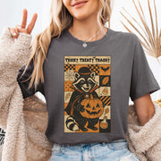 Dracula Raccoon Halloween T-shirt featuring a raccoon with pumpkin and retro comic style design.