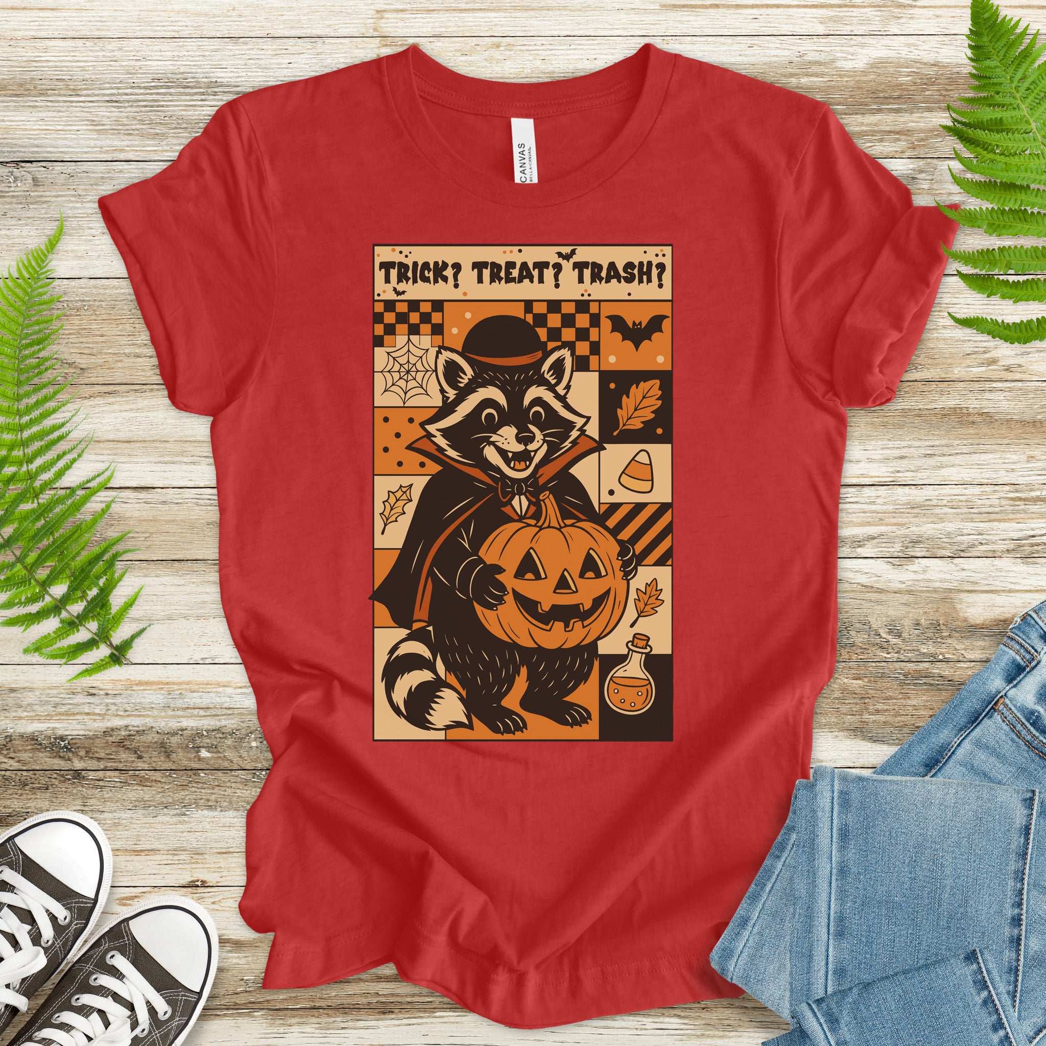 Dracula Raccoon Halloween T-shirt featuring a raccoon in a cape holding a pumpkin, with retro comic panel designs.