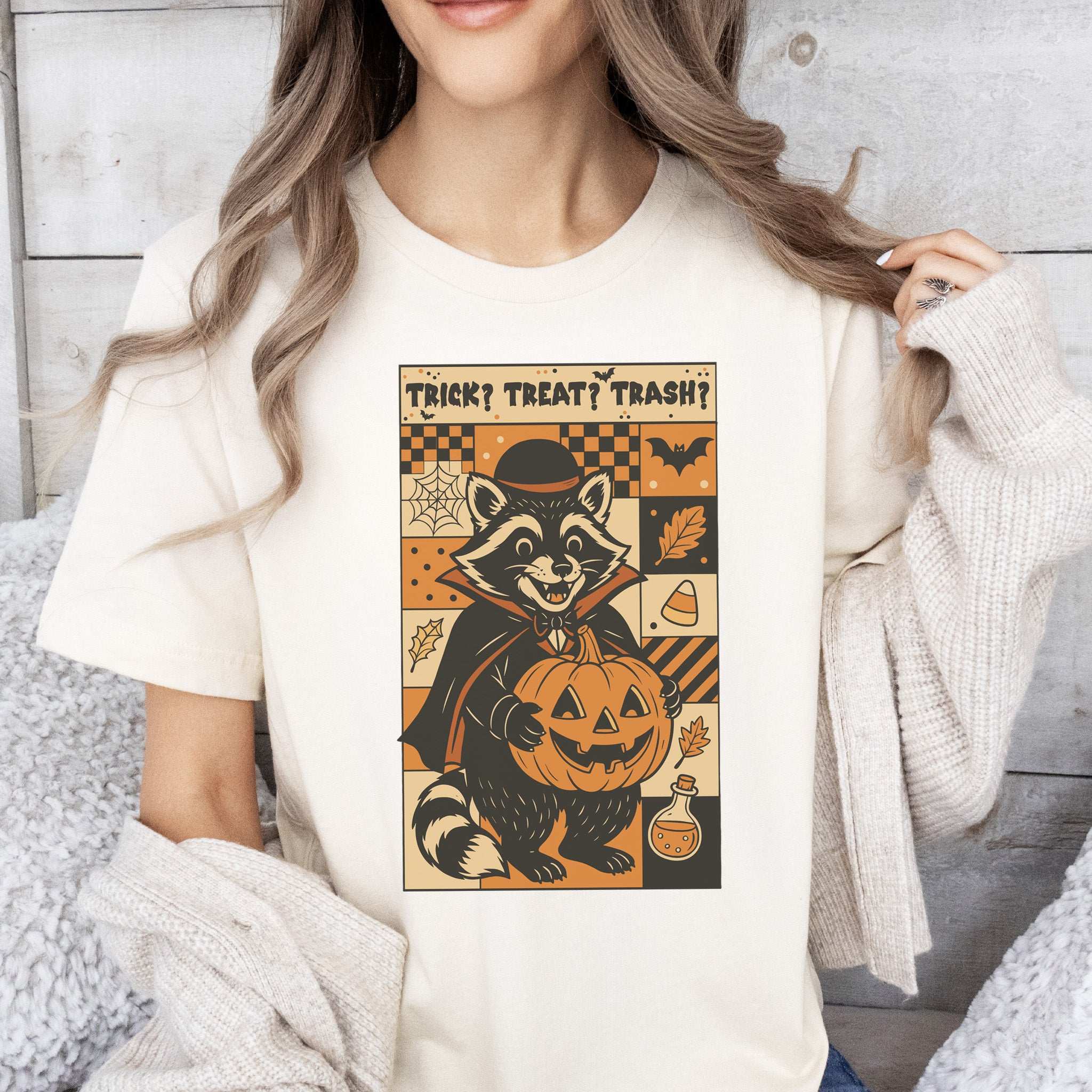 Dracula Raccoon Halloween T-shirt featuring trick or treat theme with pumpkin graphic.