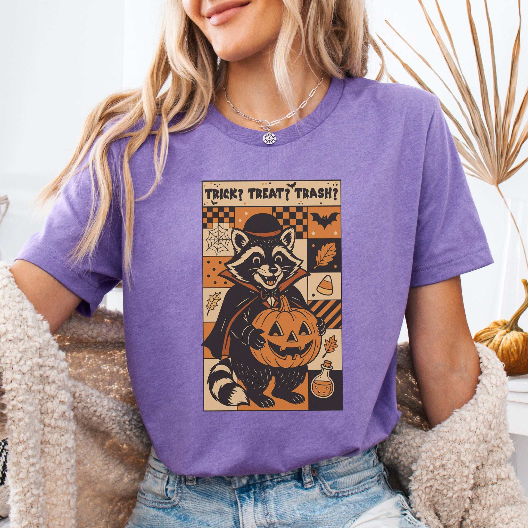 Dracula Raccoon Halloween T-shirt featuring a retro design with a raccoon in a cape holding a pumpkin.