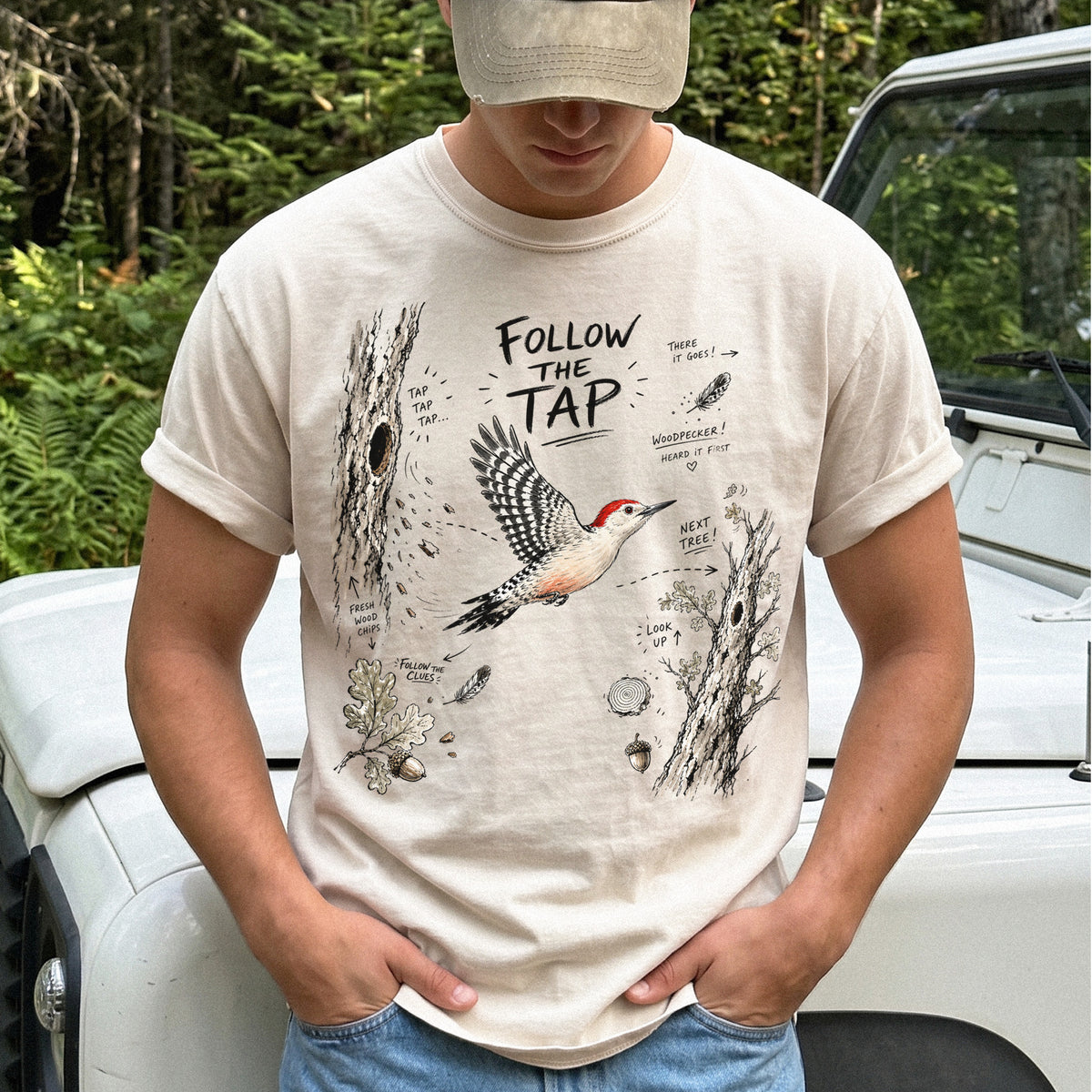 Follow the Tap Comfort Colors Shirt – Red-Bellied Woodpecker design of a Red-Bellied Woodpecker illustrated in flight, surrounded by tree trunks, wood chips, feathers, oak leaves, and acorn details, printed on an Ivory T-shirt.