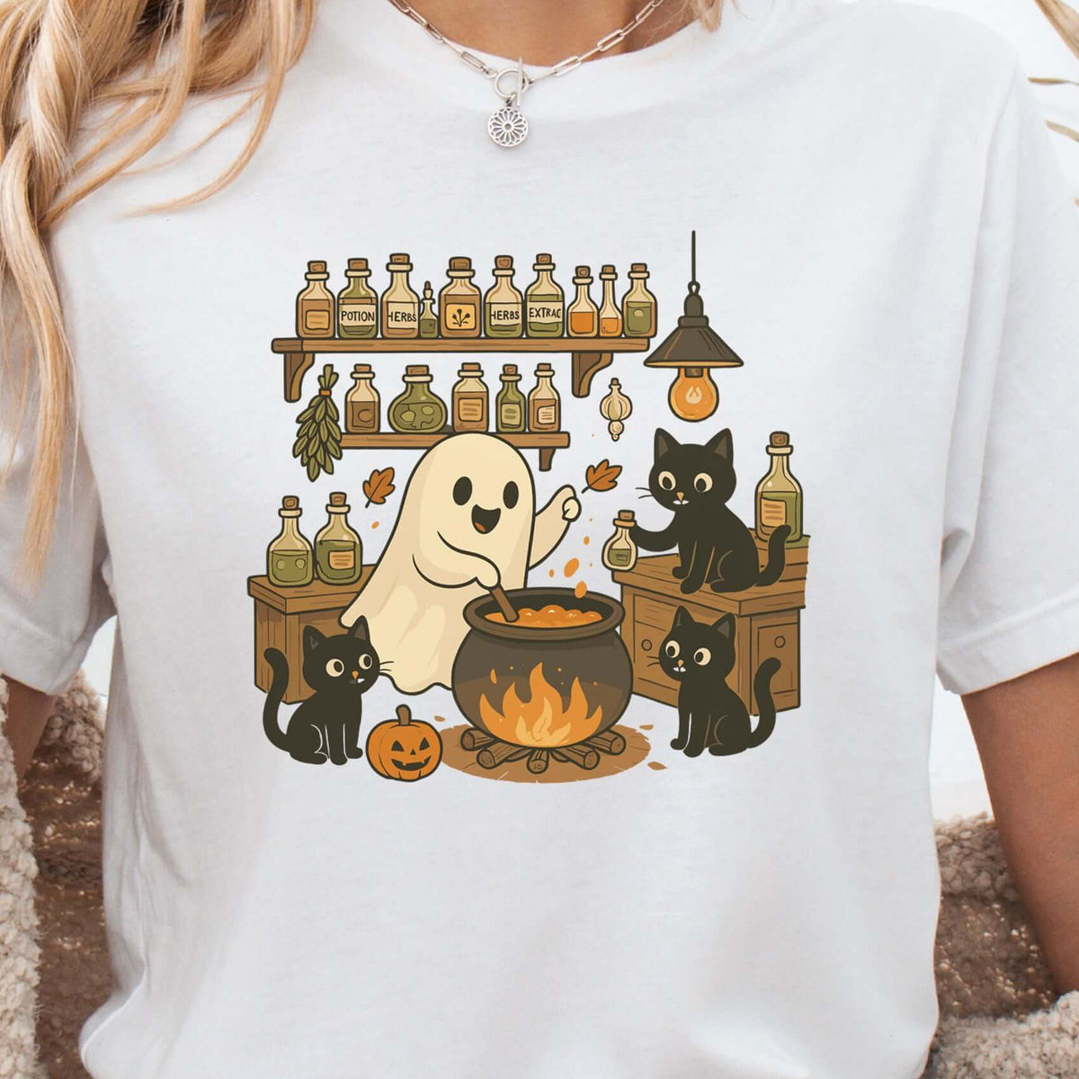 Woman wearing a White T-shirt printed with a ghost and three black cats brewing a potion in a kitchen, retro illustration