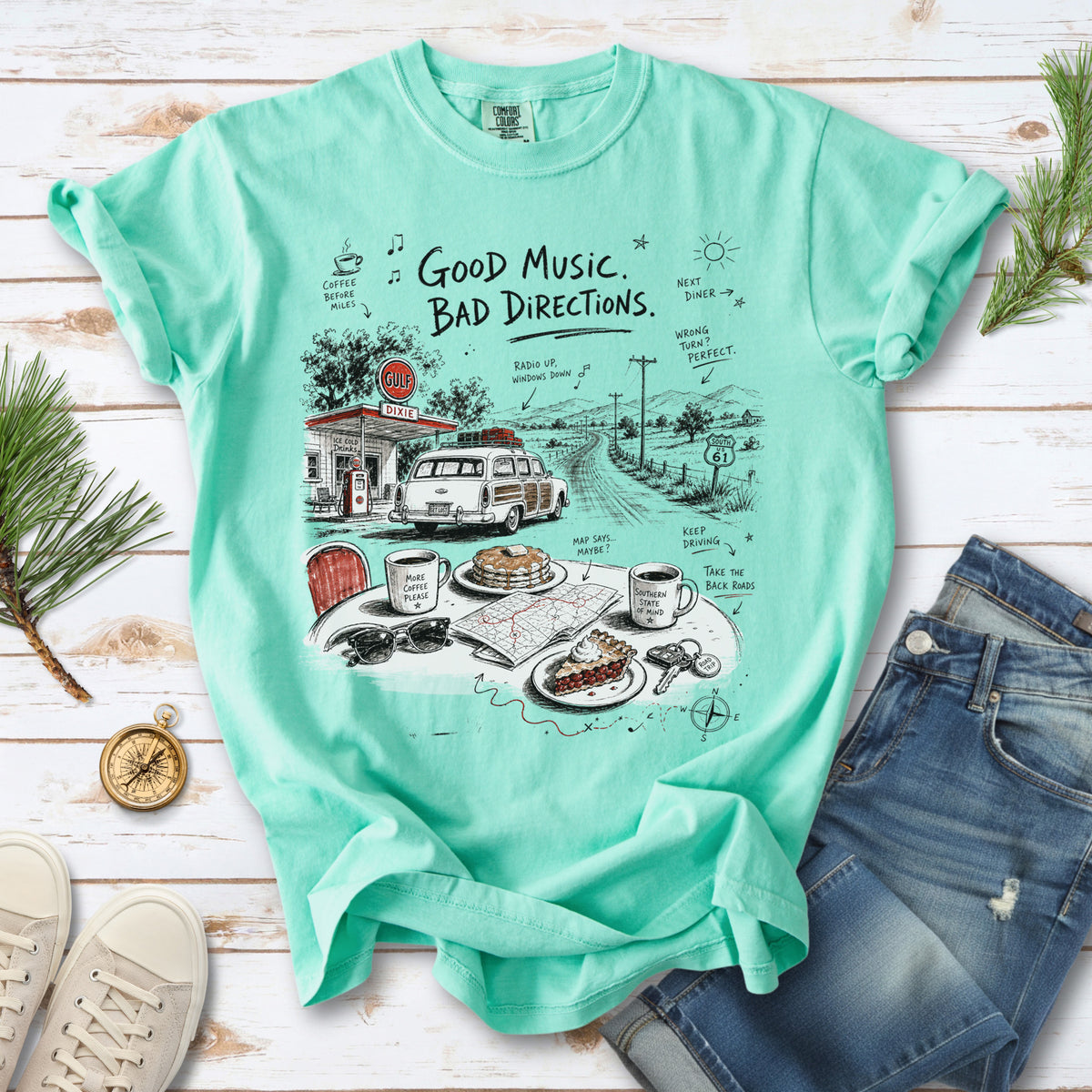 A vintage roadside scene with a classic car, old gas station, and a winding back road design on an Island Reef Comfort Colors T-shirt
