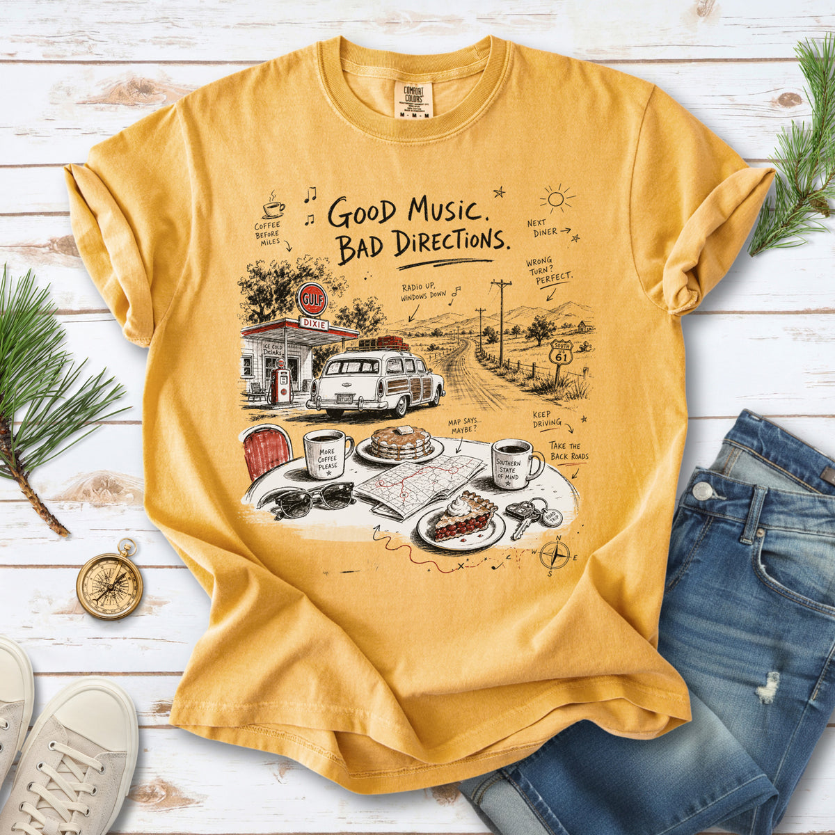 A vintage roadside scene with a classic car, old gas station, and a winding back road design on a Mustard Comfort Colors T-shirt