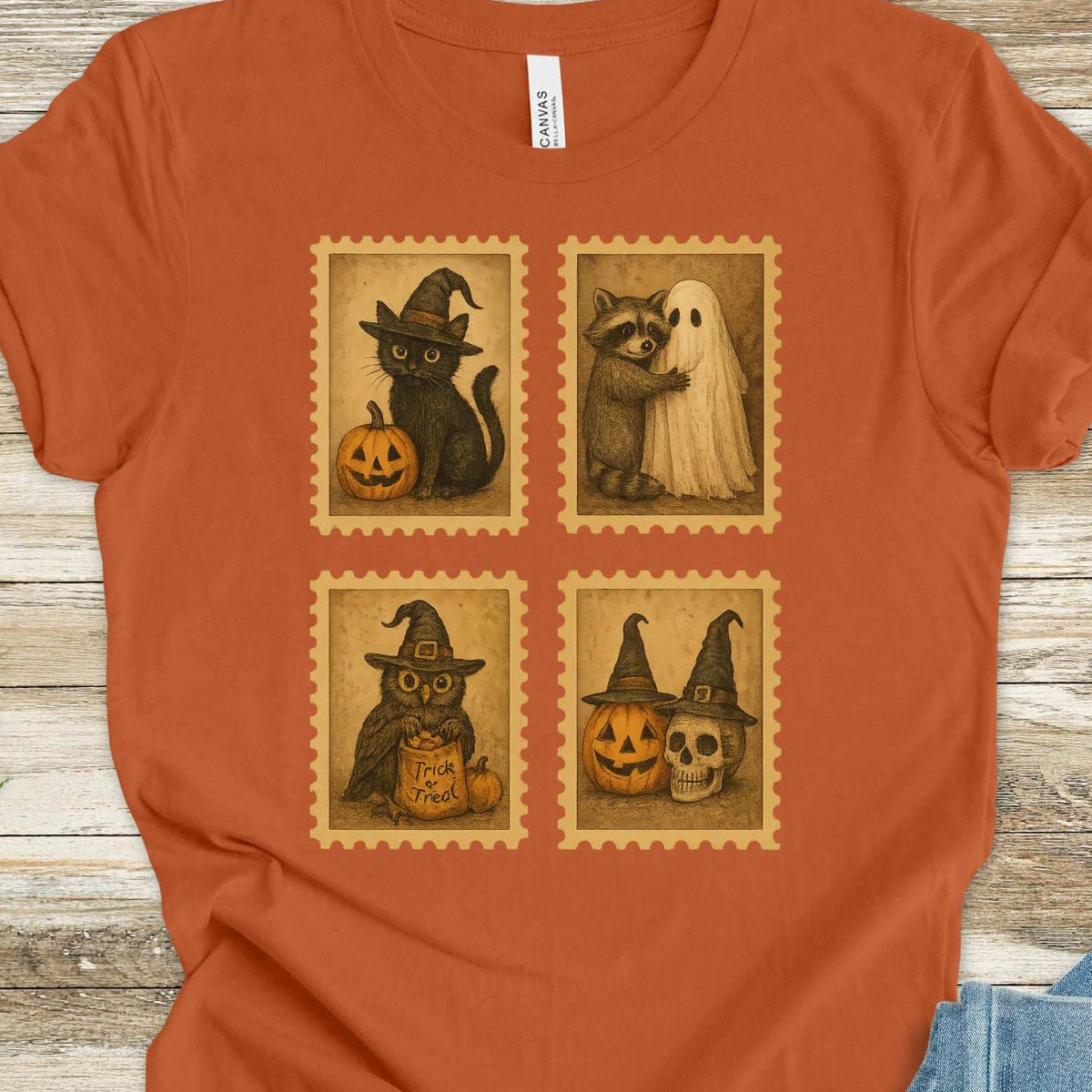 Vintage-style Halloween postage stamps featuring a black cat, a raccoon, a trick-or-treat owl, and a pumpkin skull design on an Autumn T-shirt
