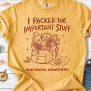 An overstuffed backpack with a thermos, mug, compass, trail map, and festive treats, doodle style design on a Mustard T-shirt