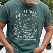 Man wearing a Blue Spruce T-shirt printed with a winding trail with a tent, compass, backpack, trekking poles, snowflakes, and pine trees, doodle style