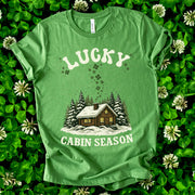 Lucky Cabin Season T-Shirt – Cozy Snowy Forest Tee for St. Patrick’s Day