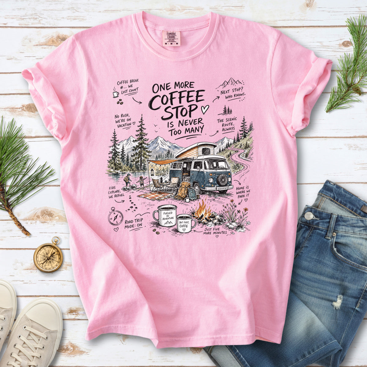 A retro camper van parked by the water with mountain views and camp chairs design on a Blossom Comfort Colors T-shirt