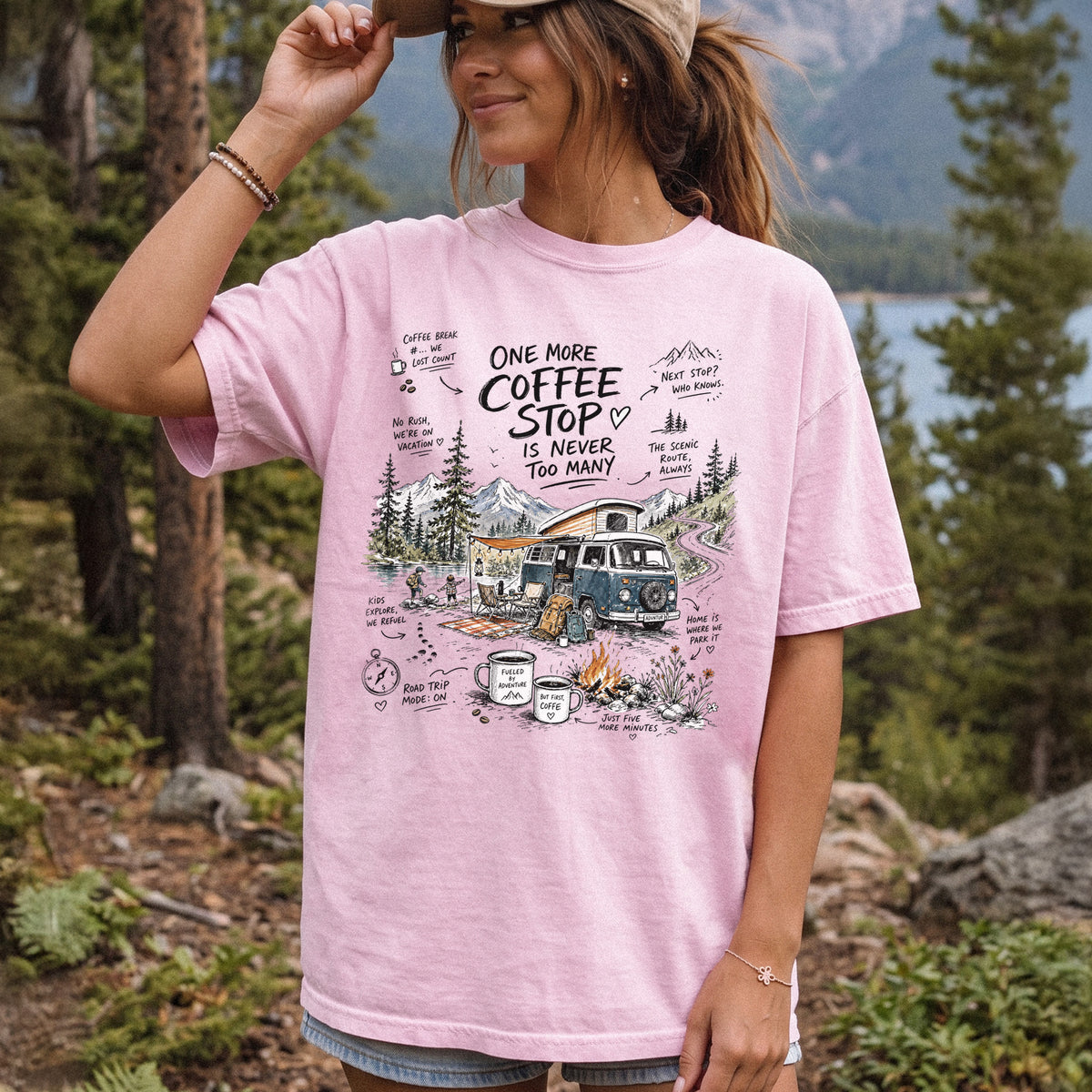 Woman wearing a Blossom Comfort Colors T-shirt printed with a retro camper van parked by the water with mountain views and camp chairs