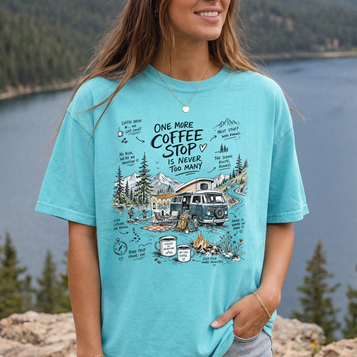 Woman wearing a Chalky Mint Comfort Colors T-shirt printed with a retro camper van parked by the water with mountain views and camp chairs