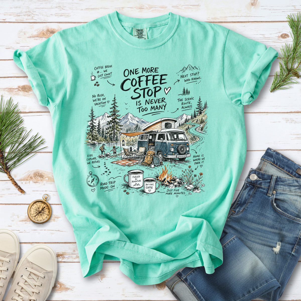 A retro camper van parked by the water with mountain views and camp chairs design on an Island Reef Comfort Colors T-shirt