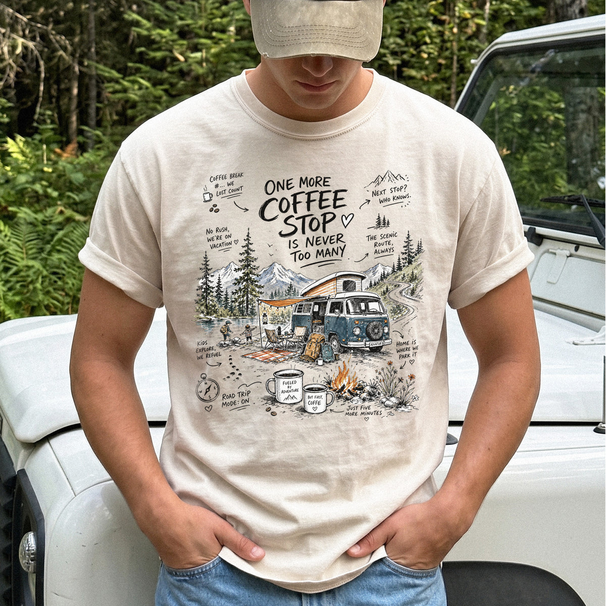 Man wearing an Ivory Comfort Colors T-shirt with a retro camper van parked by the water with mountain views and camp chairs