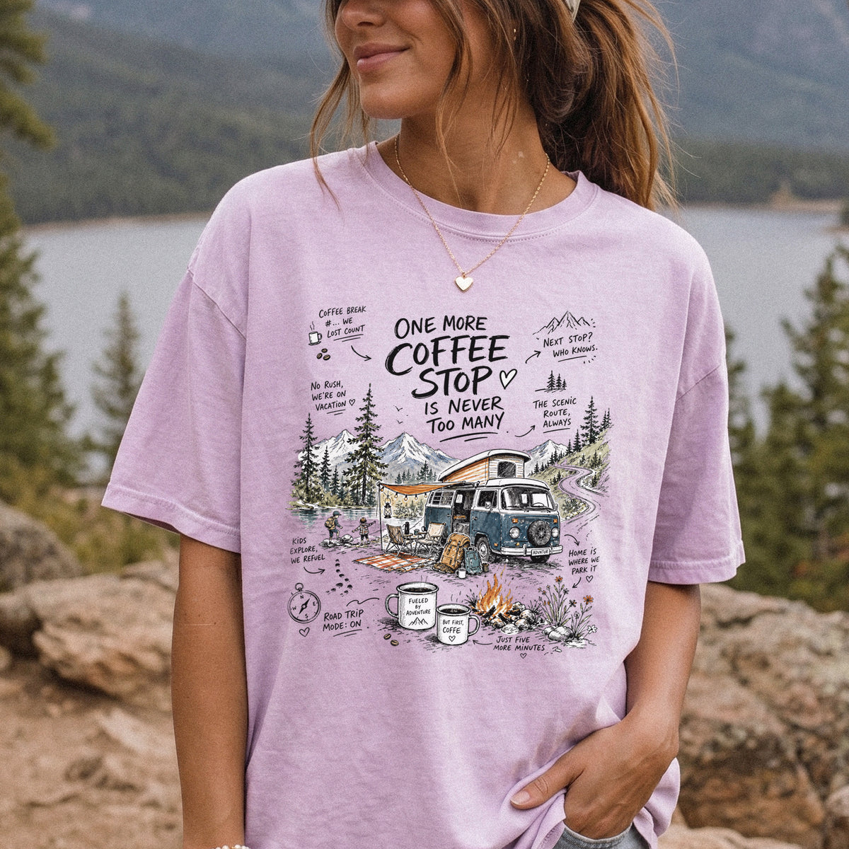 Woman wearing an Orchid Comfort Colors T-shirt printed with a retro camper van parked by the water with mountain views and camp chairs