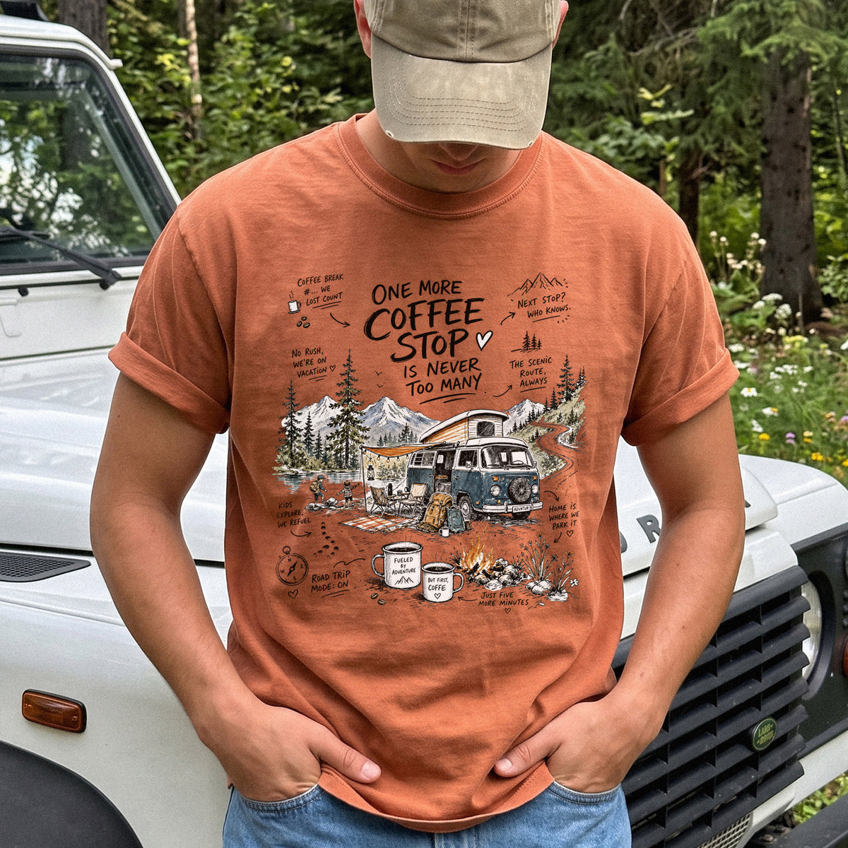 Man wearing a Yam Comfort Colors T-shirt with a retro camper van parked by the water with mountain views and camp chairs