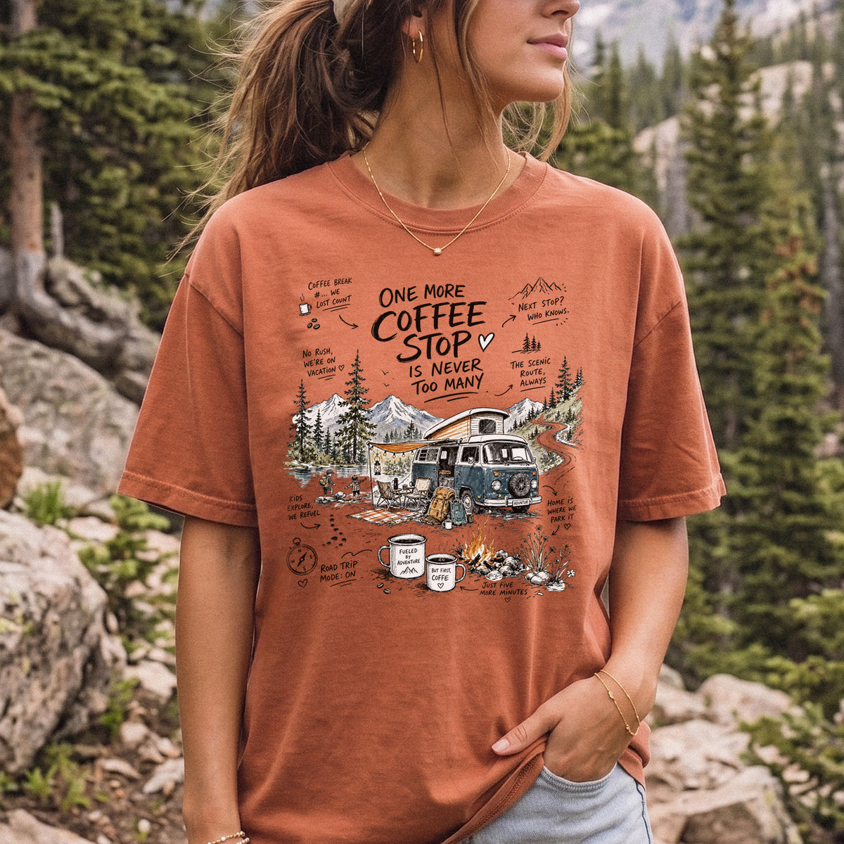 Woman wearing a Yam Comfort Colors T-shirt printed with a retro camper van parked by the water with mountain views and camp chairs