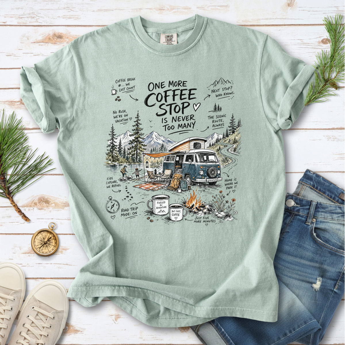 A retro camper van parked by the water with mountain views and camp chairs design on a Bay Comfort Colors T-shirt
