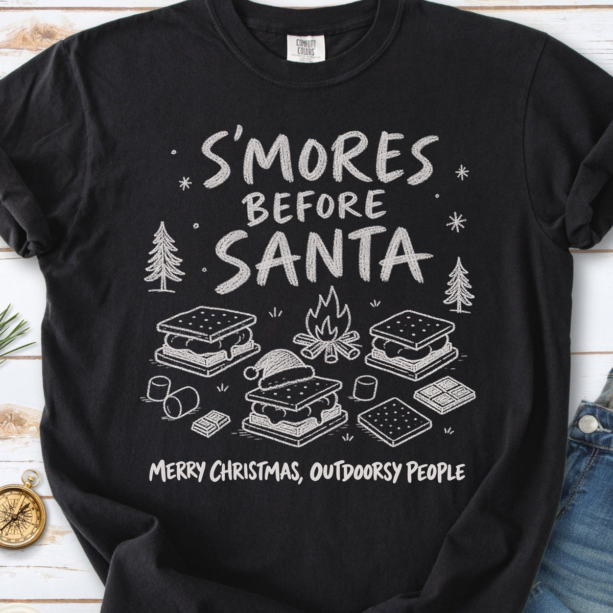S’mores, a crackling campfire, marshmallows, chocolate pieces, pine trees, and a tiny Santa hat, doodle style design on a Black T-shirt