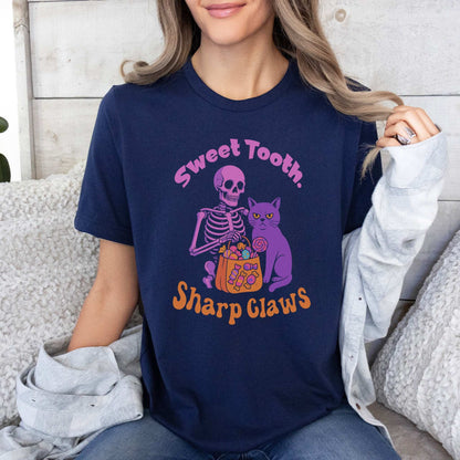 Skeleton and Grumpy Cat Halloween T-shirt with text 'Sweet Tooth, Sharp Claws' on a navy background.