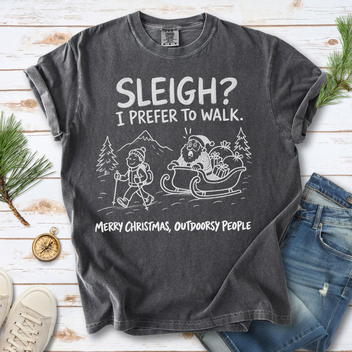A hiker with trekking poles and a surprised Santa in his sleigh against a mountain backdrop, doodle line-art style design on a Pepper T-shirt