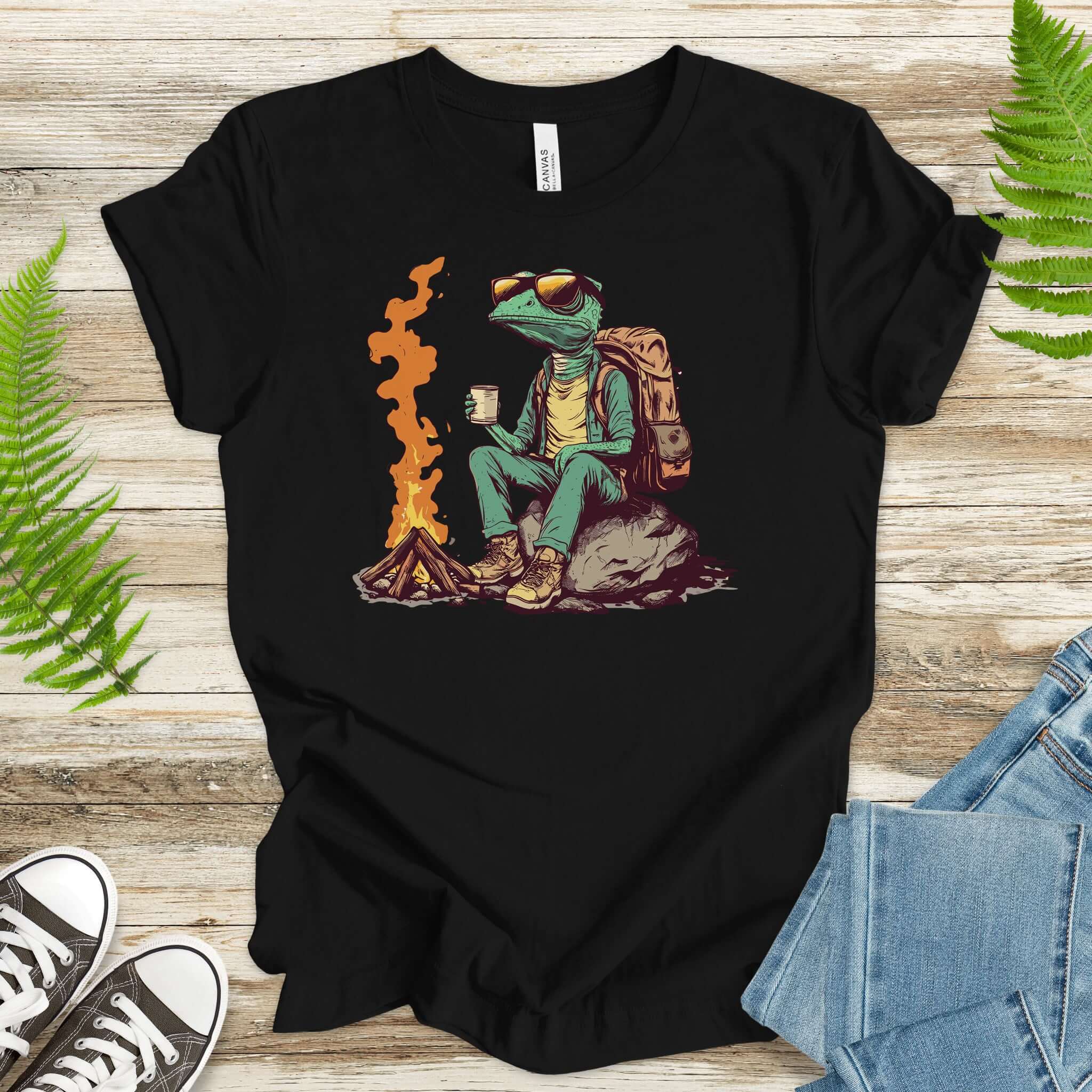 Chameleon sitting near a campfire t-shirt, featuring a chameleon in hiking gear enjoying a drink by the fire.