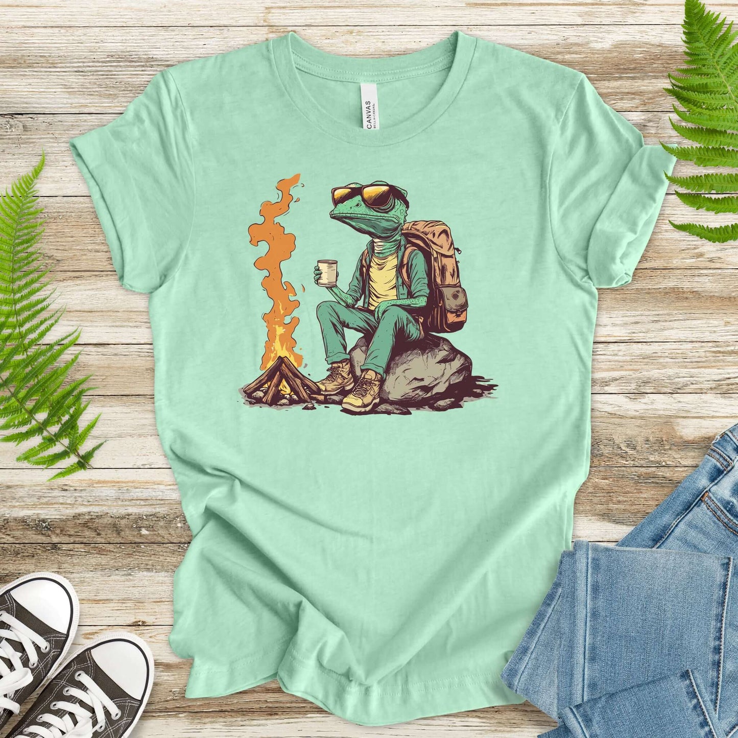 Chameleon sitting near a campfire t-shirt in mint green, featuring a cool reptile with hiking gear.