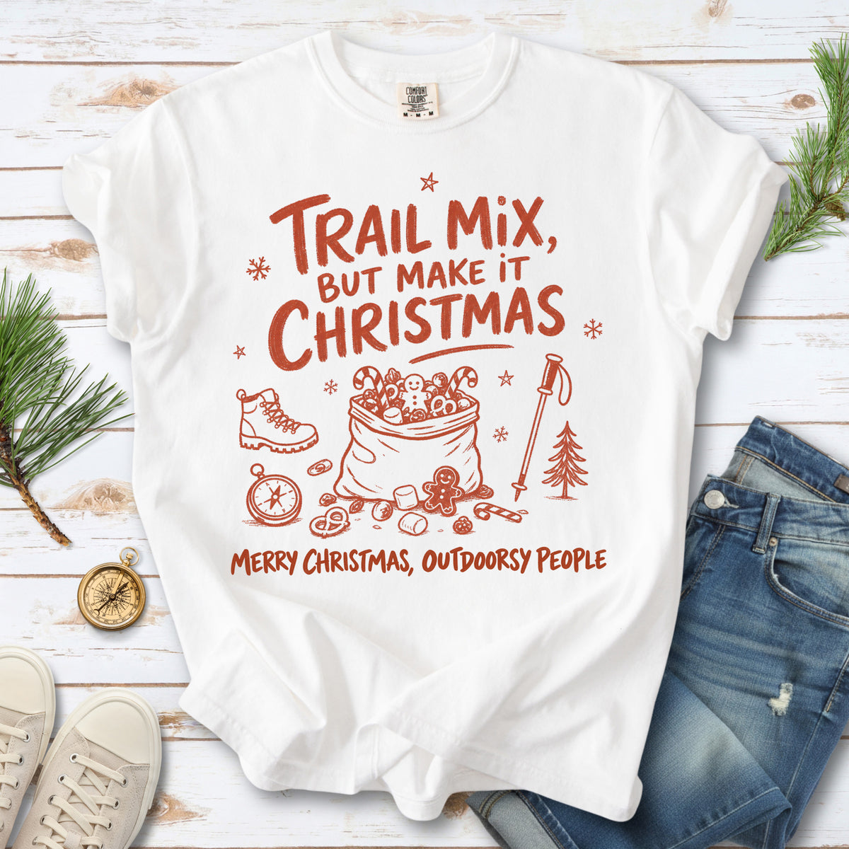 Festive trail snacks, candy canes, a gingerbread cookie, a hiking boot, compass, and trekking pole, doodle style design on a White T-shirt