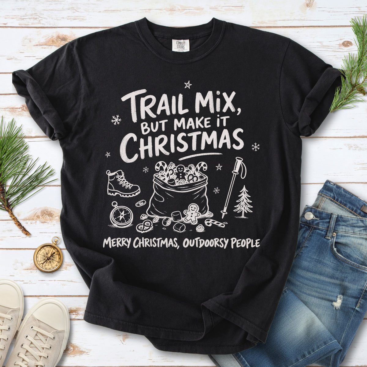Festive trail snacks, candy canes, a gingerbread cookie, a hiking boot, compass, and trekking pole, doodle style design on a Black T-shirt
