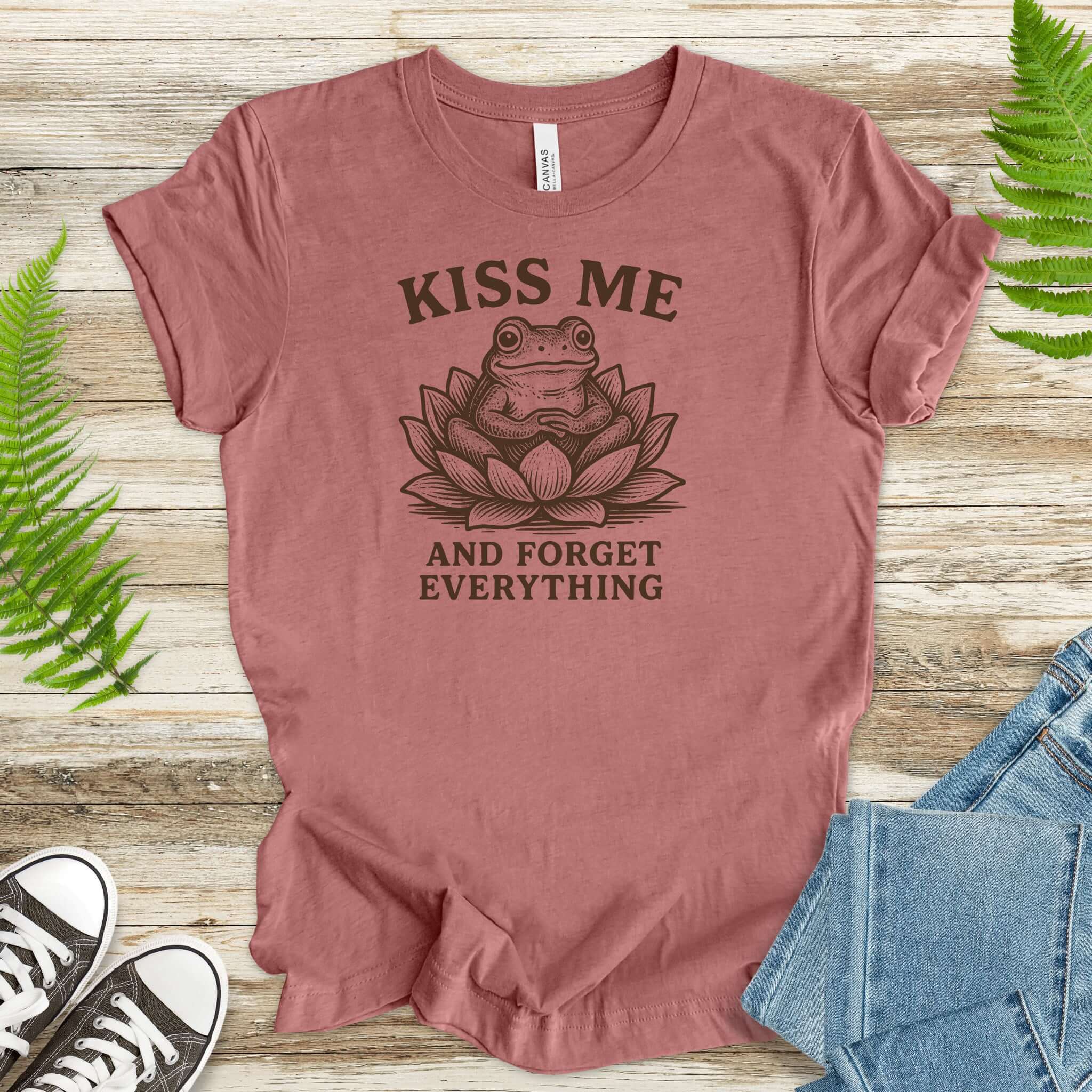 Kiss Me and Forget Everything Tee featuring a funny frog in a lotus flower, perfect for whimsical style lovers.