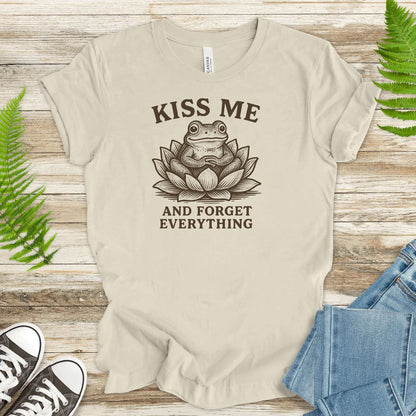Funny frog in lotus flower tee saying 'Kiss Me and Forget Everything' for a whimsical touch.